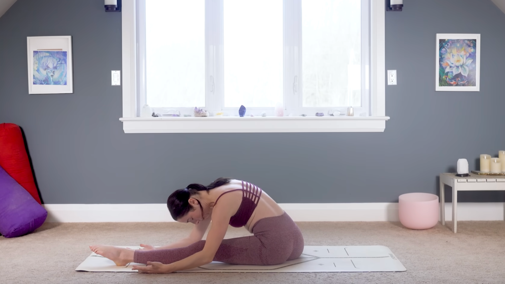Woman leaning forward in a hip-opening stretch on a yoga mat