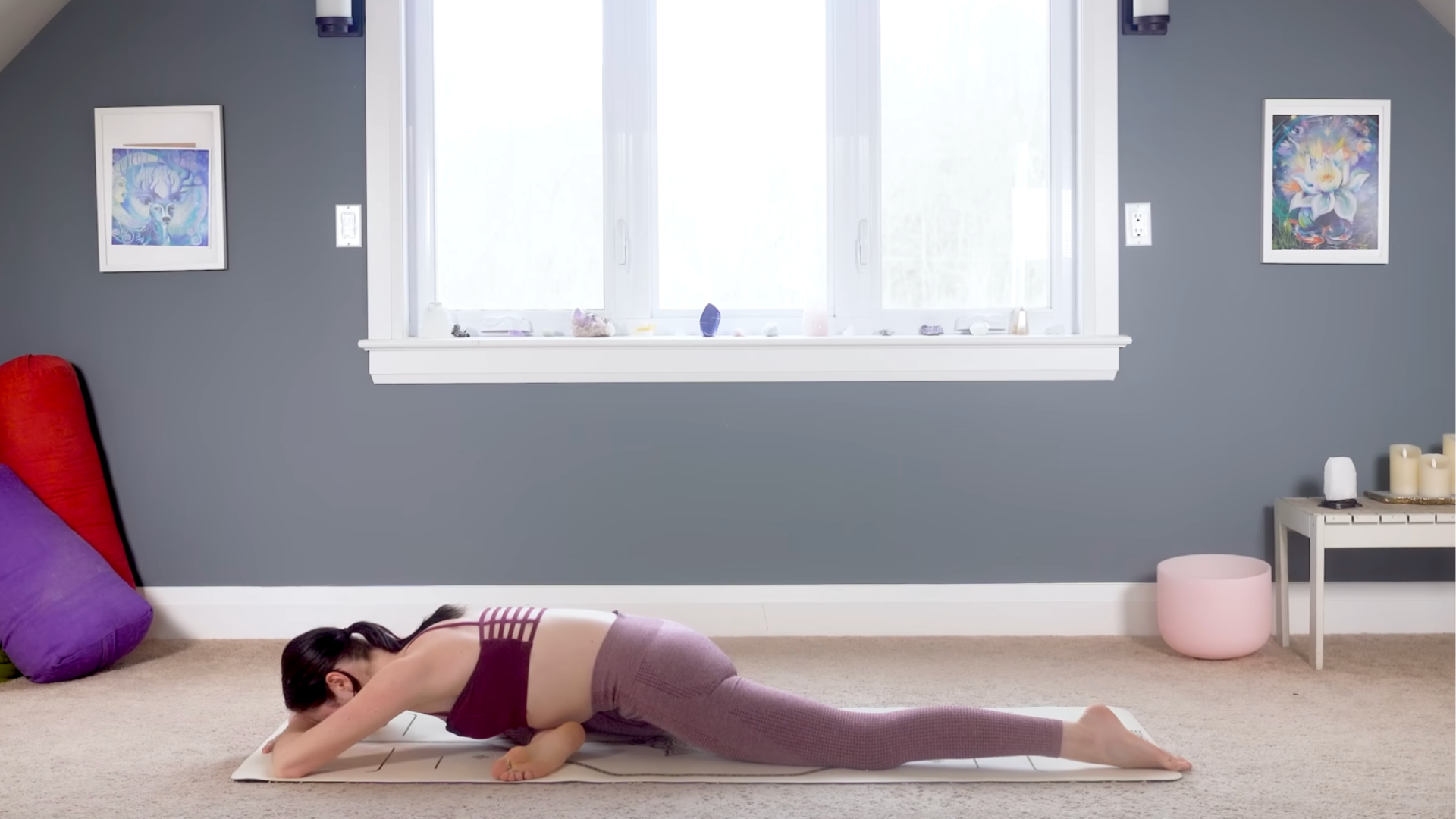 Woman leaning forward on a yoga mat in Pigeon Pose