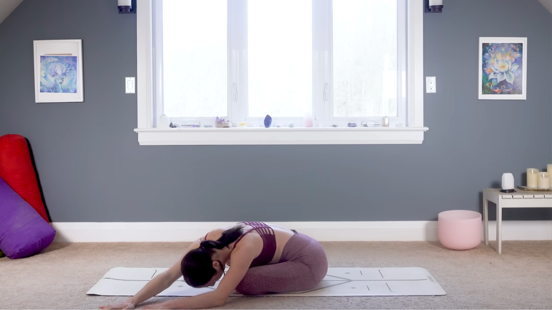 Woman on a yoga mat practicing hip opening stretches
