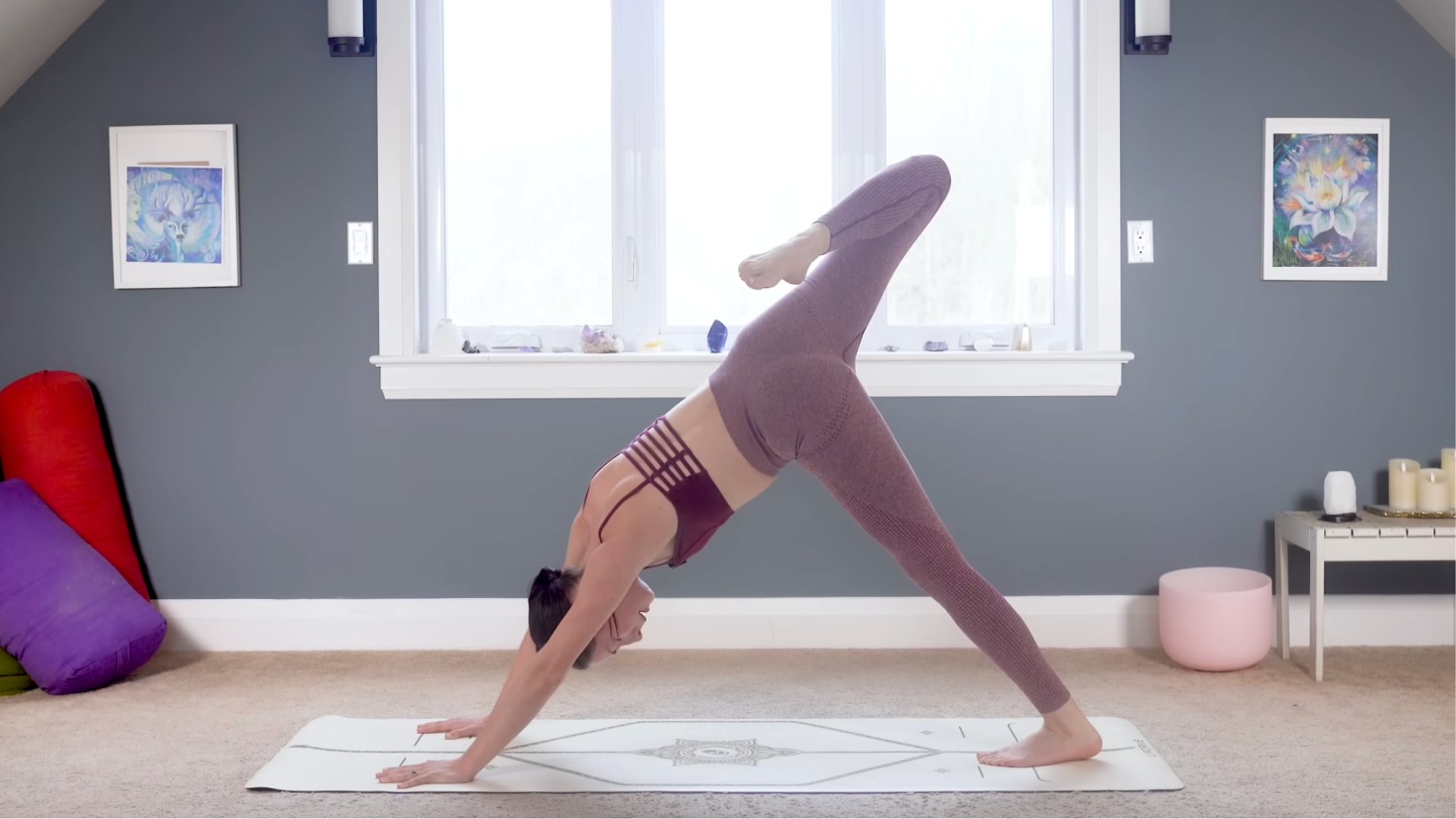 Woman on a yoga mat in three-legged dog with the knee bent to stretch the hip flexors