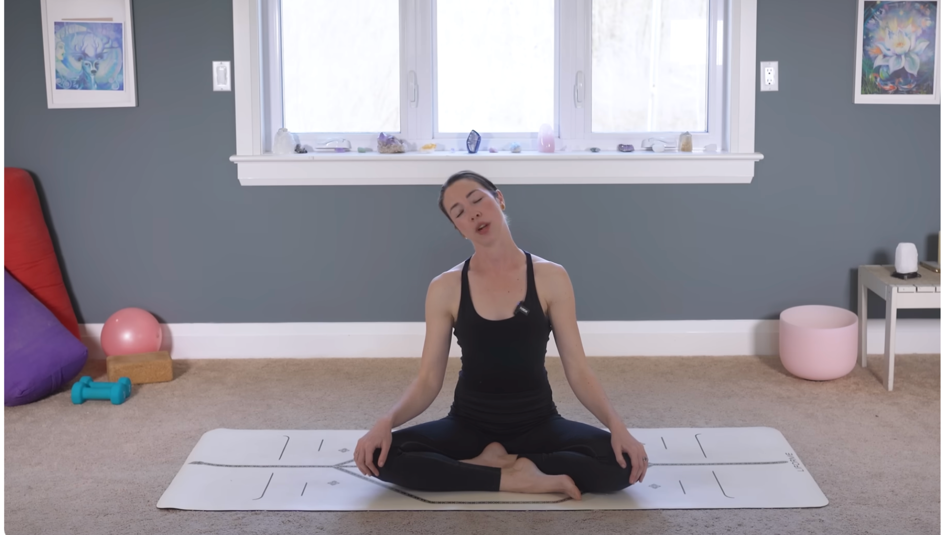 Yoga teacher sitting on a mat practicing neck stretches during a 10-minute morning yoga routine