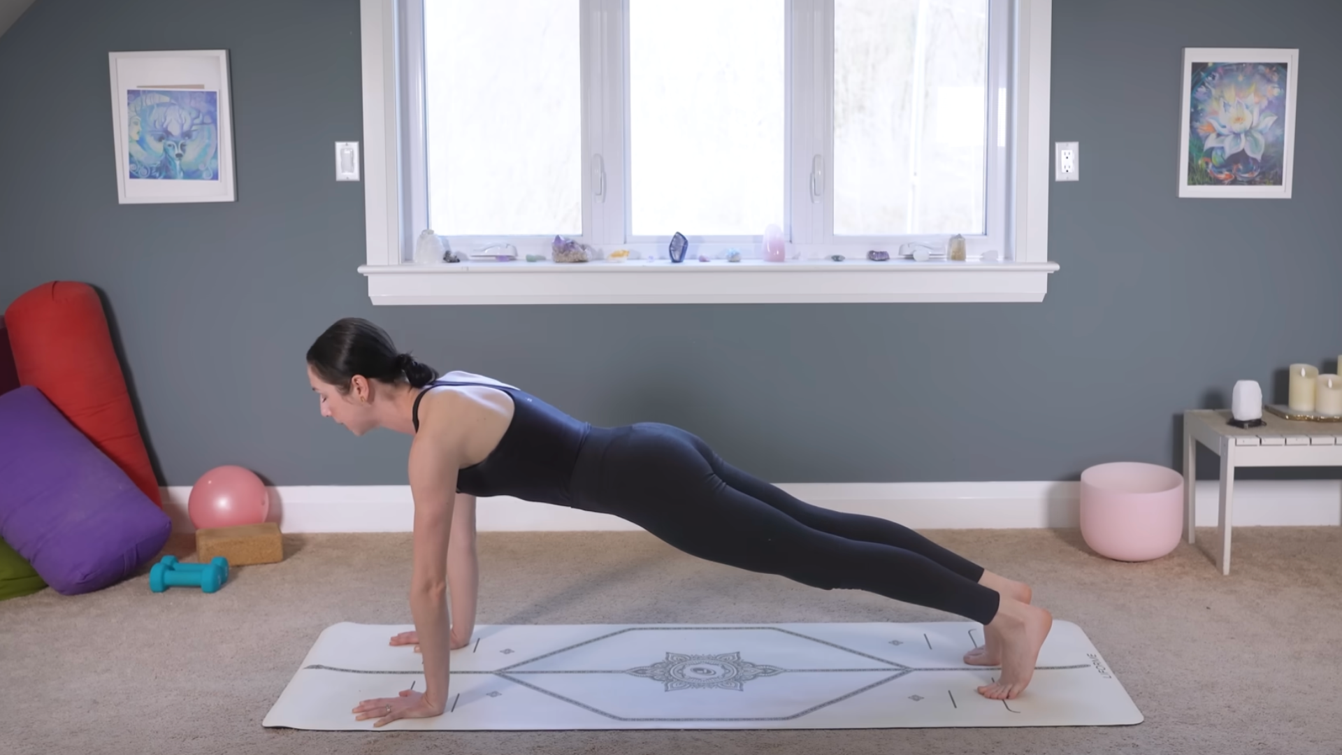 Yoga teacher in Plank Pose on a mat
