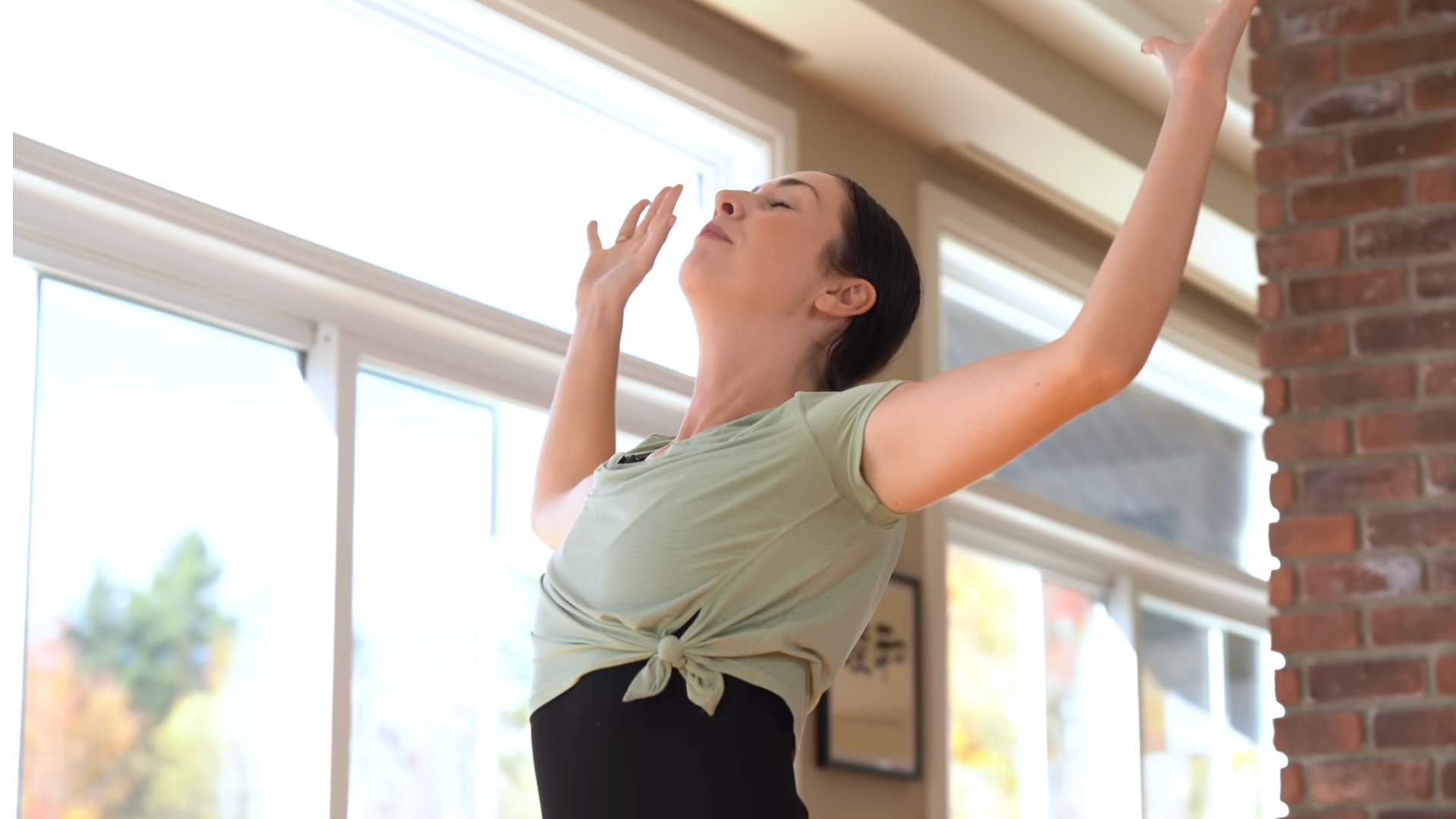 Woman practicing 15-minute morning yoga with a standing backbend