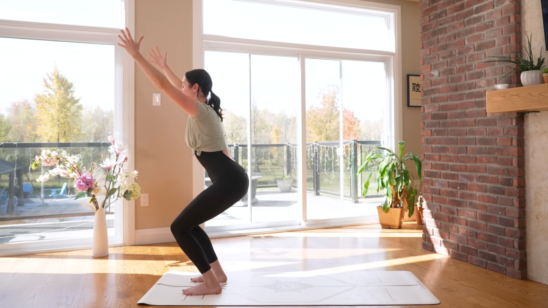 Woman on a mat practicing Chair Pose during a 15-minute morning yoga class