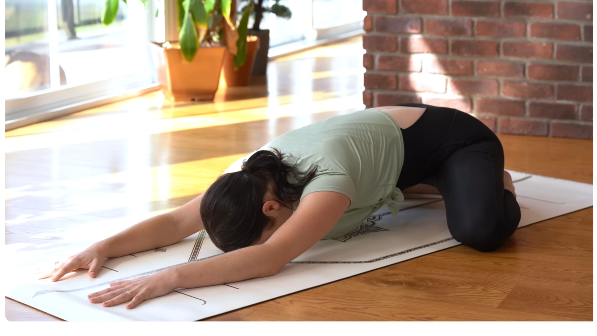 Woman in Child's Pose during a 15-minute morning yoga for stretching and strengthening