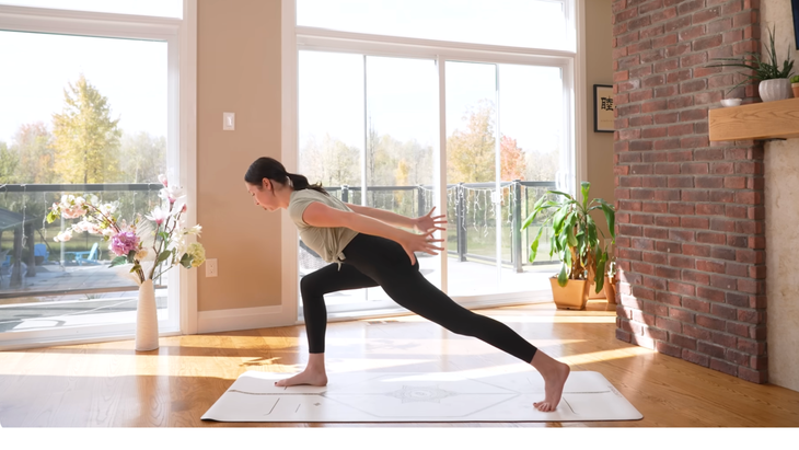 Woman in high lunge with  her arms swept back