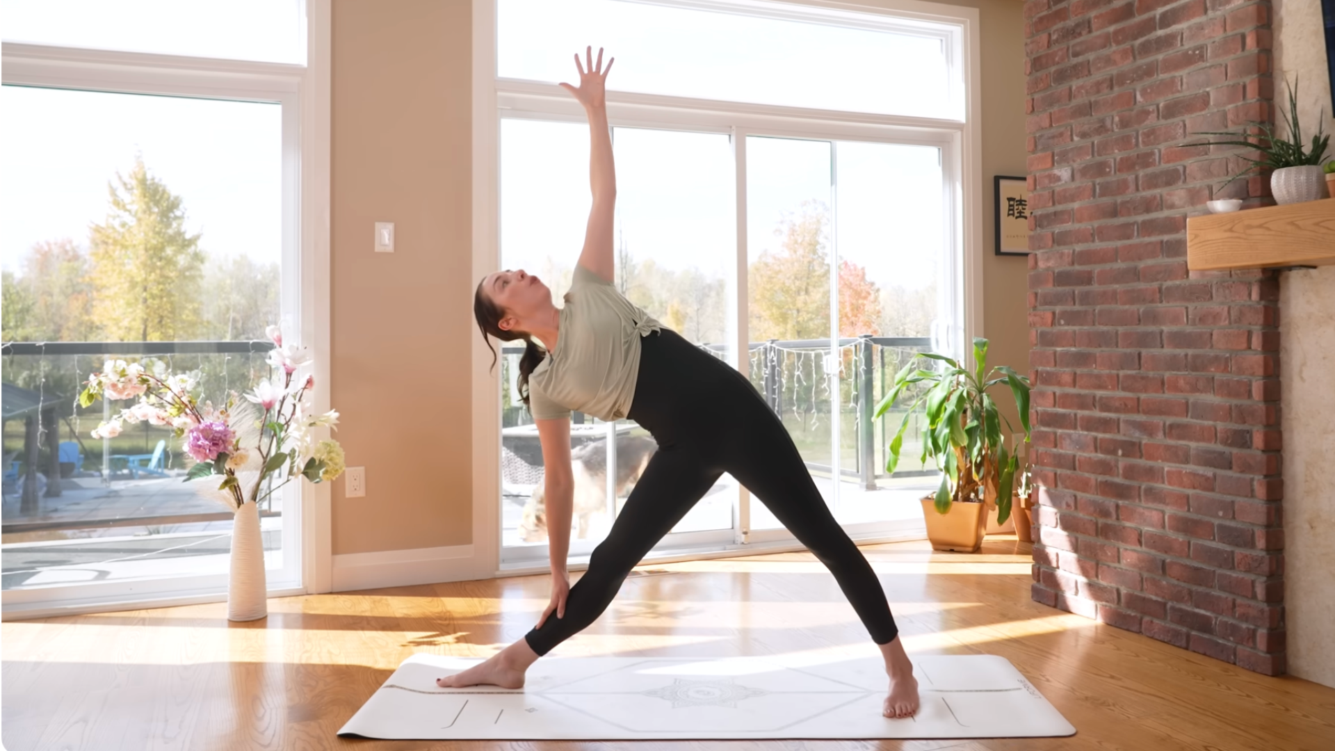 Woman in a Triangle Pose on a yoga mat during 15-minute morning yoga for stretching and strengthening