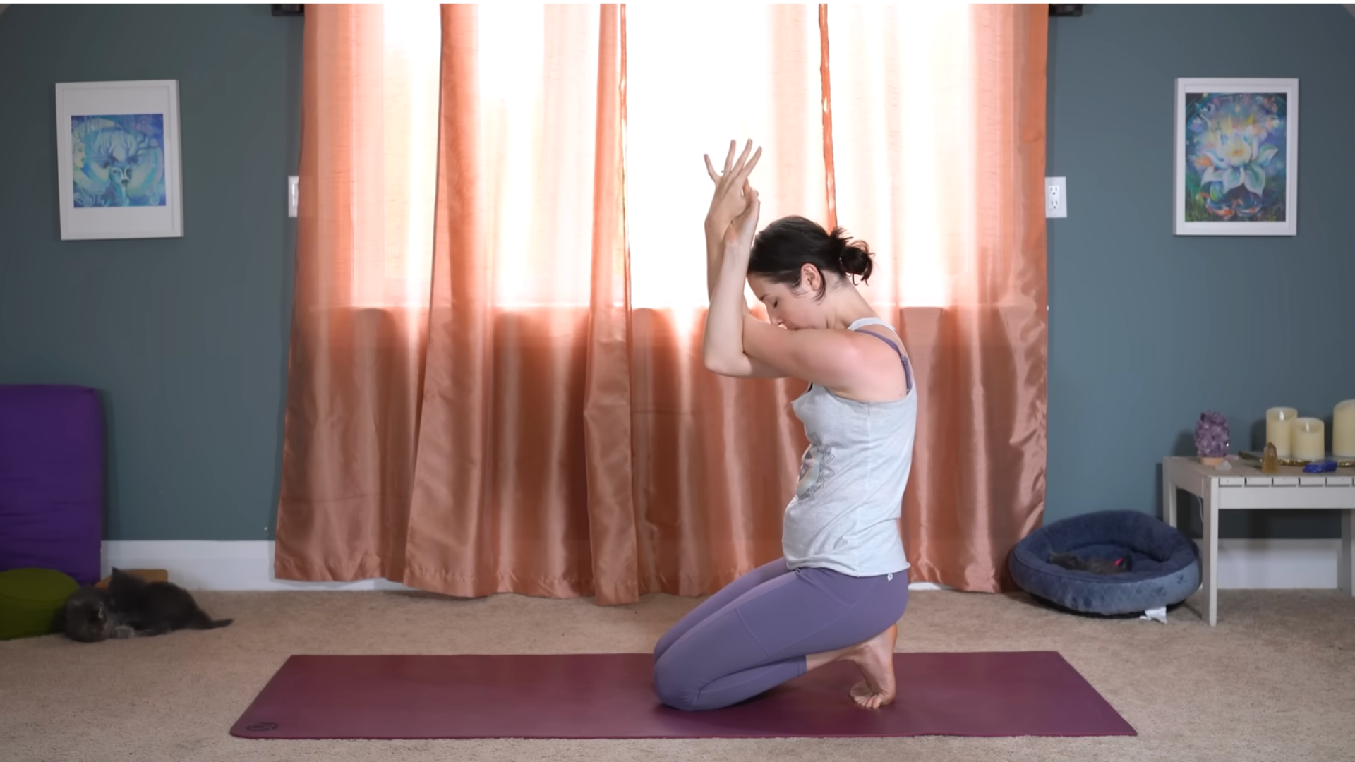 Woman kneeling on a yoga mat with her arms crossed while doing after workout stretchese