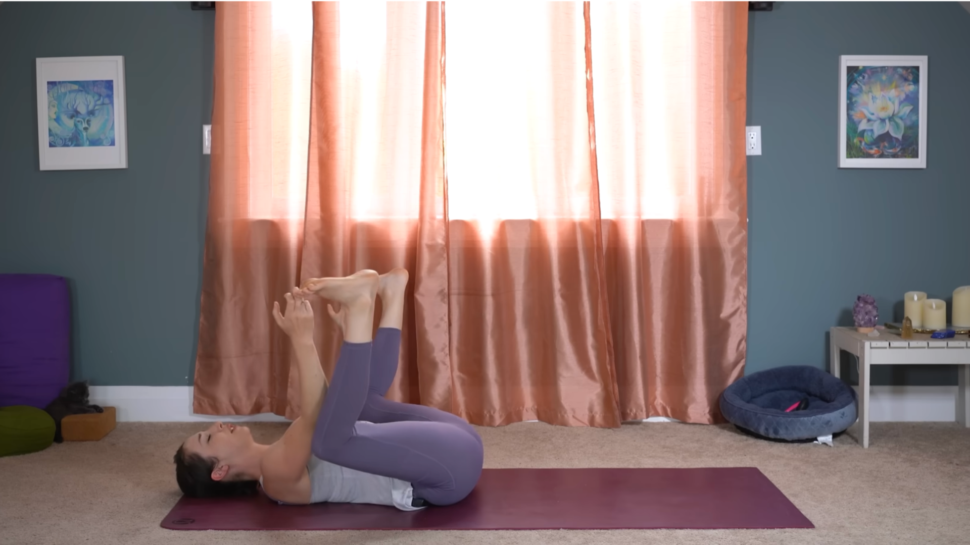 Yoga teacher lying on her back in after workout stretches including Happy Baby