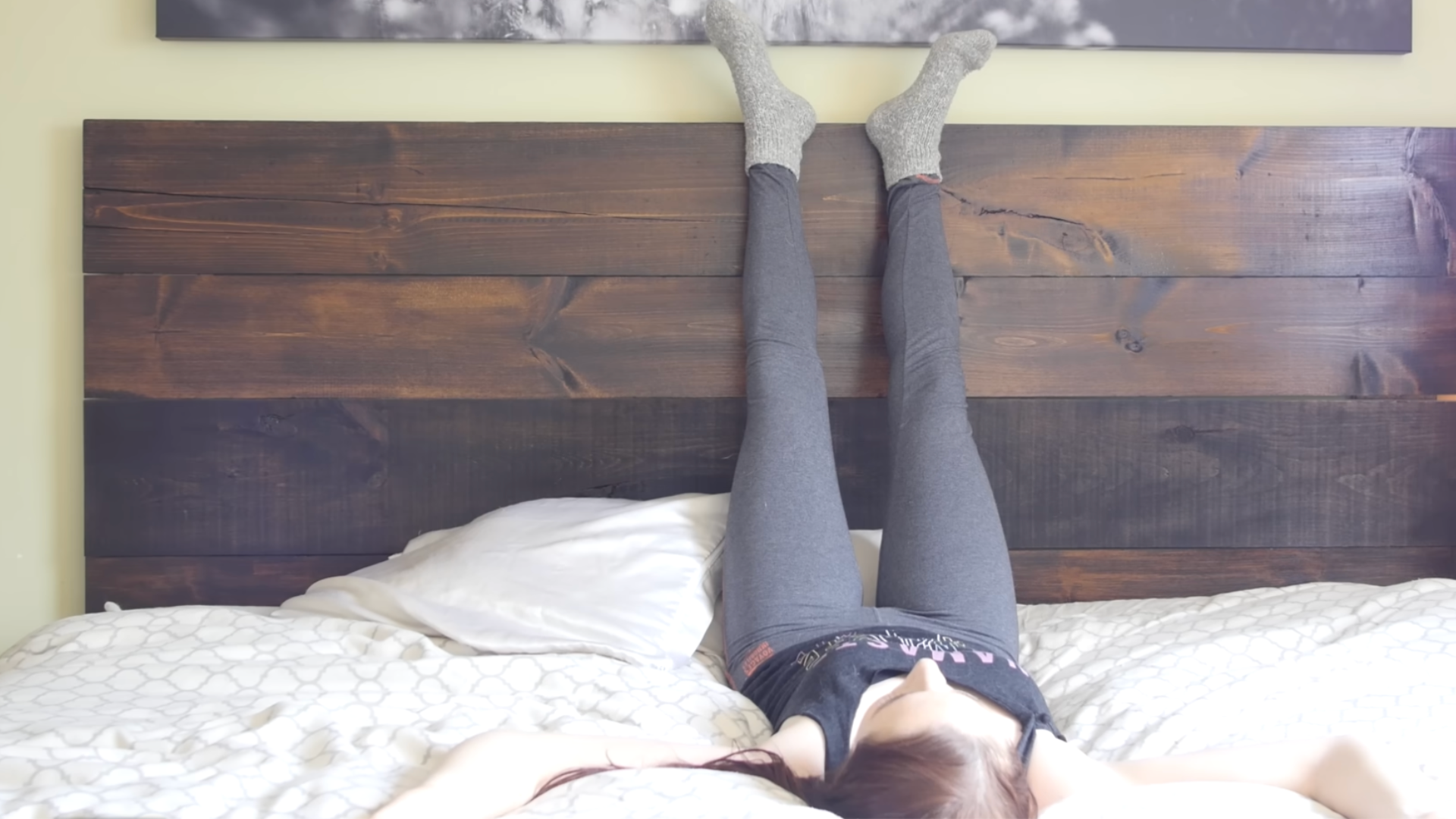 Yoga teaching practicing bedtime yoga in bed with legs up the wall