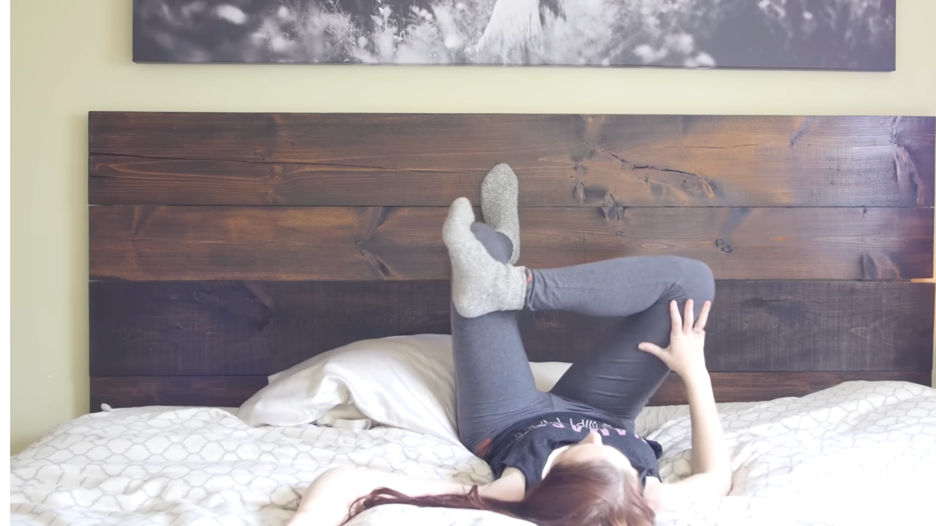 Yoga teacher in bed practicing bedtime yoga
