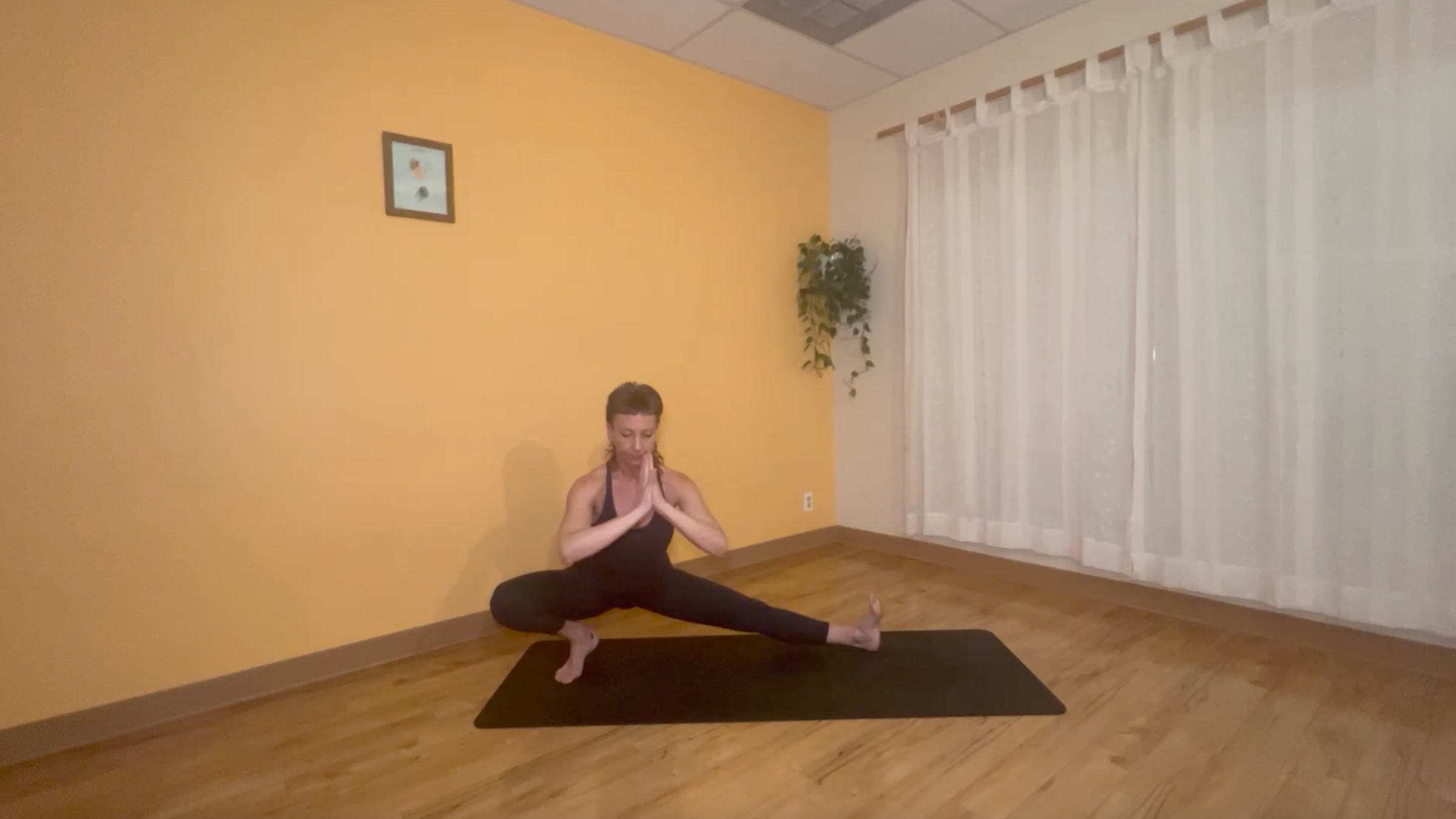 yoga teacher practicing moon salutations in half squat