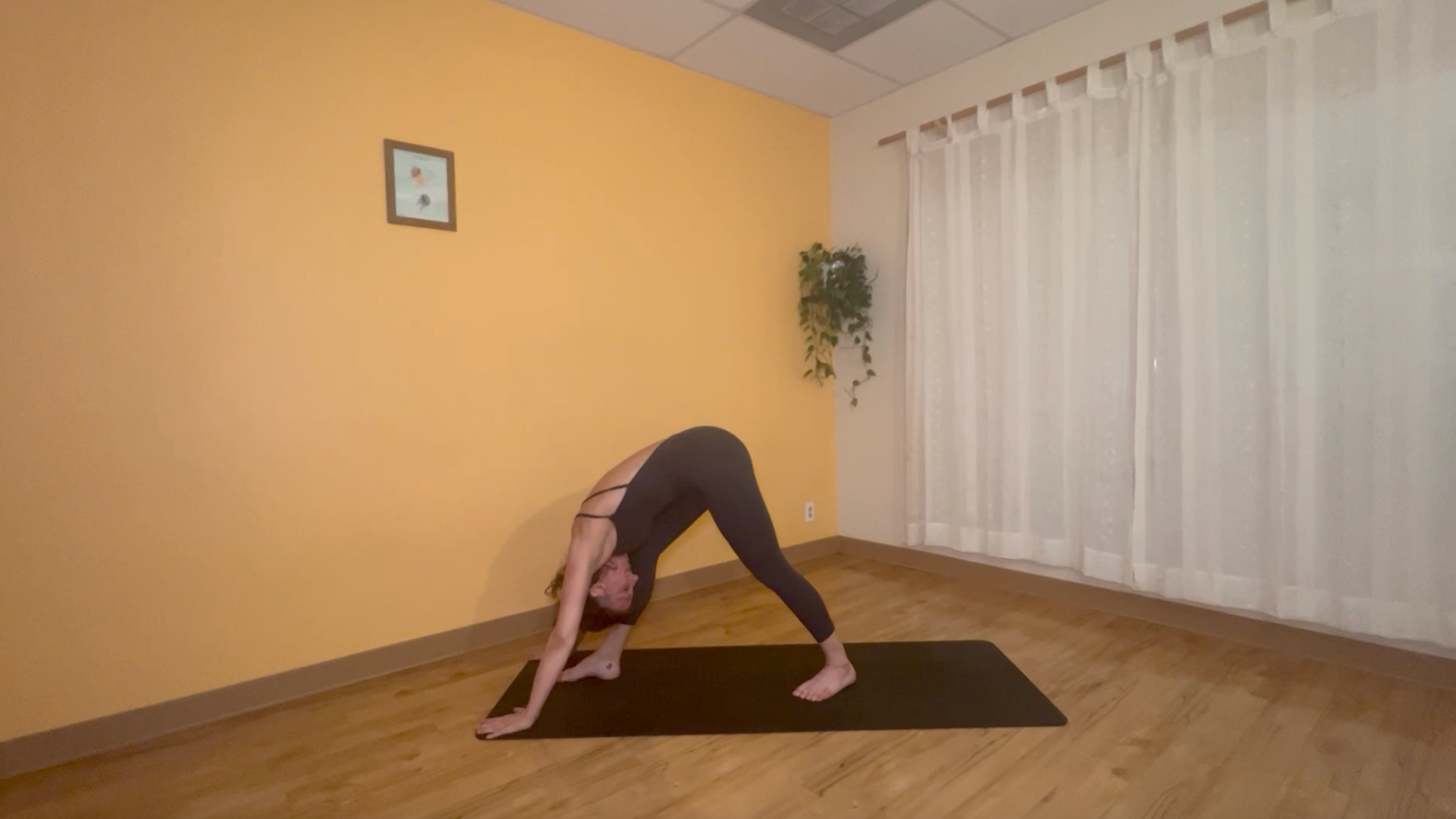 yoga teacher practicing moon salutations in pyramid pose
