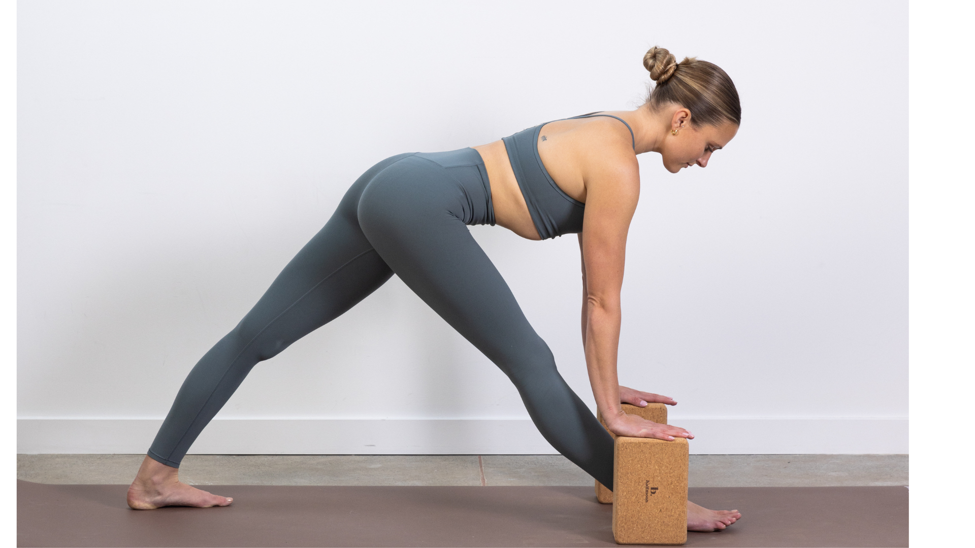 Yoga teacher in Pyramid Pose with blocks beneath her hands