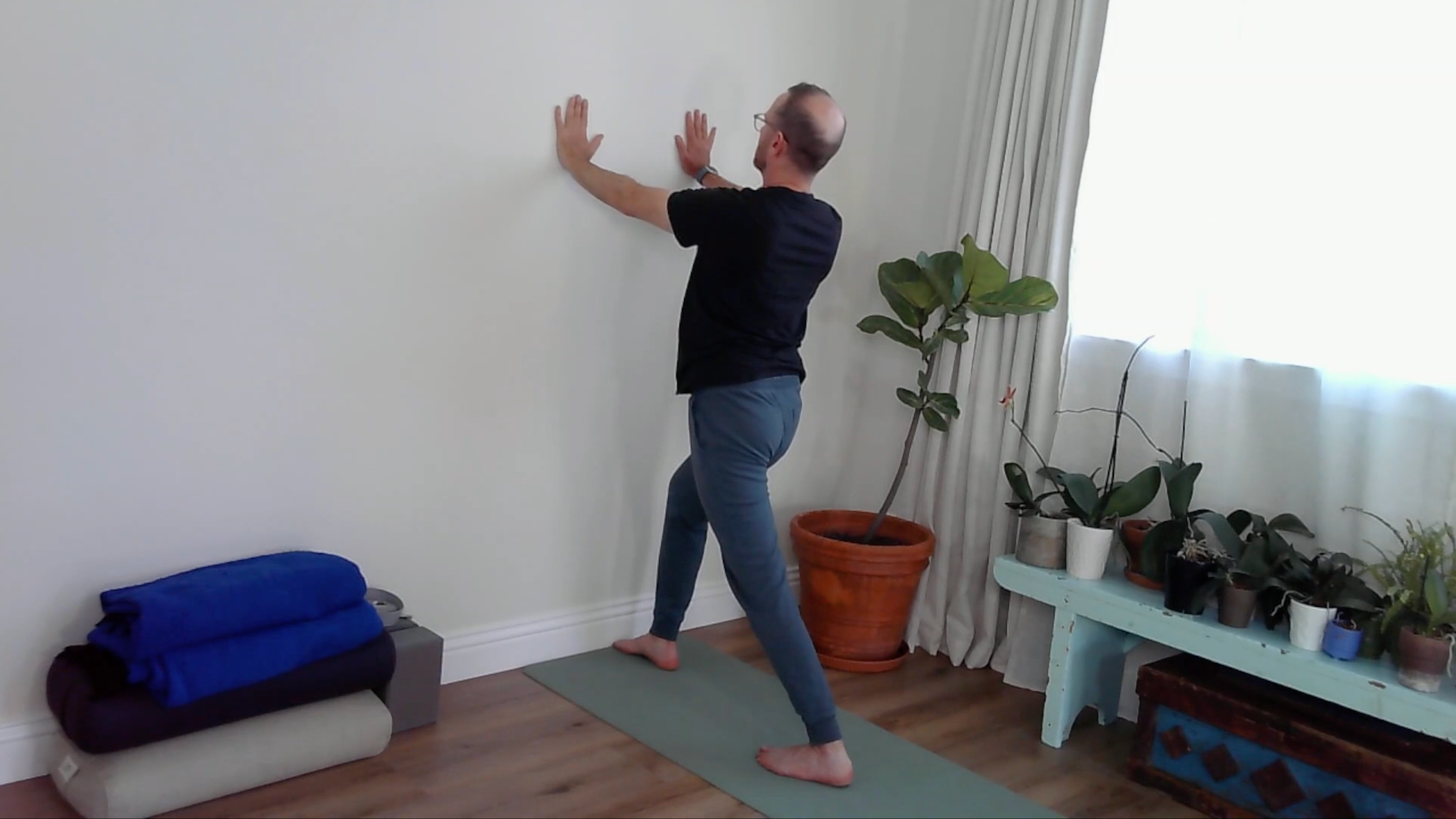 A yoga teacher in wall Low Lunge