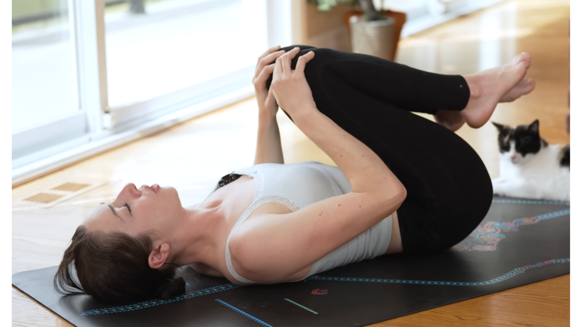 Yoga teacher practicing stretches for tight hips on a yoga mat