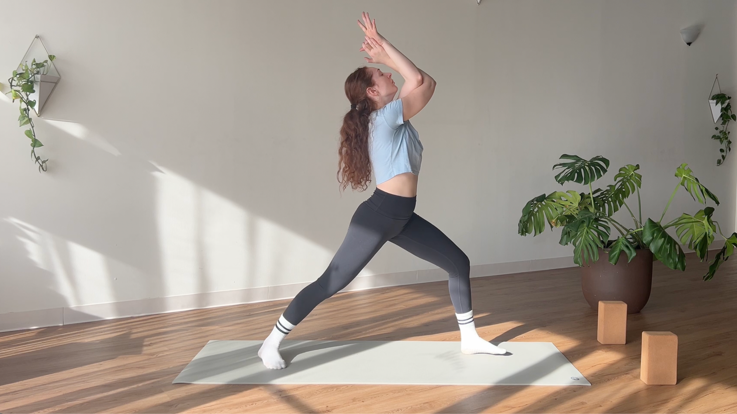 woman in Warrior 1 with Eagle Arms pose on yoga mat