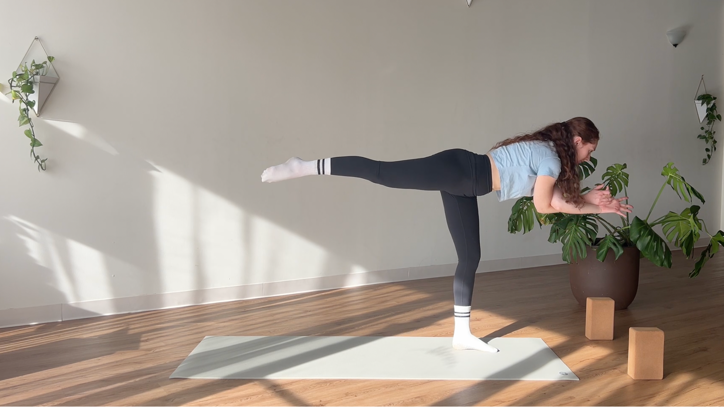 woman in Warrior 3 with Eagle Arms pose on yoga mat