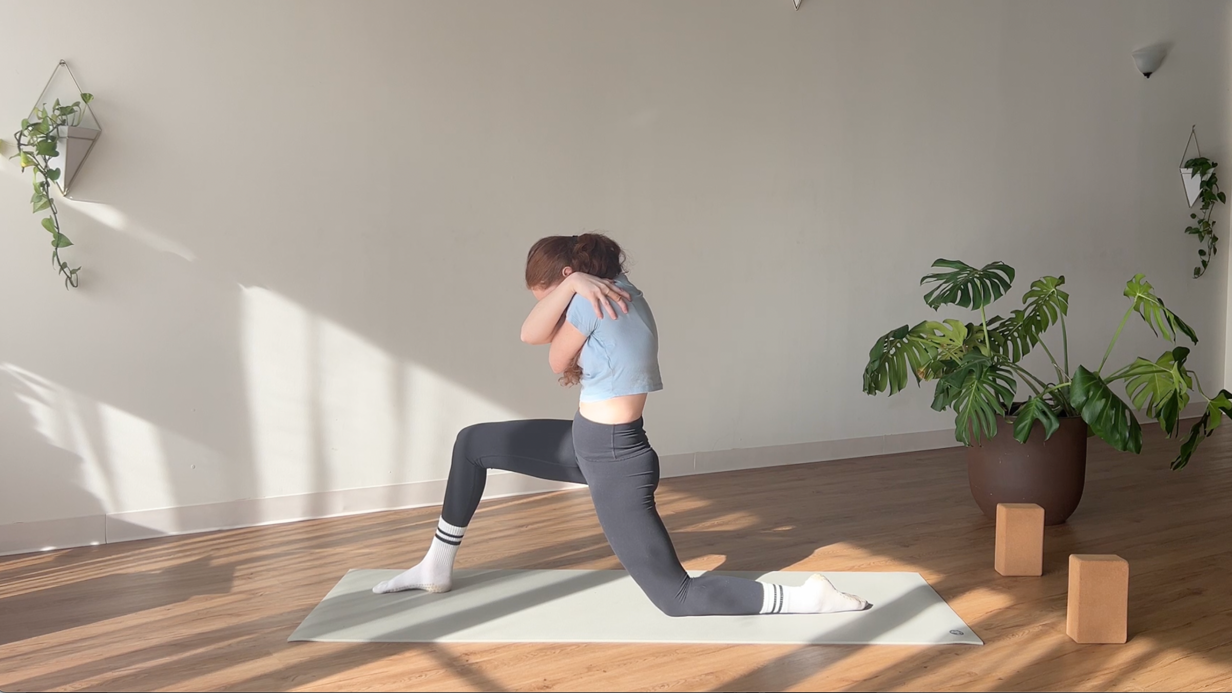 woman in Low Lunge with Hug pose on yoga mat