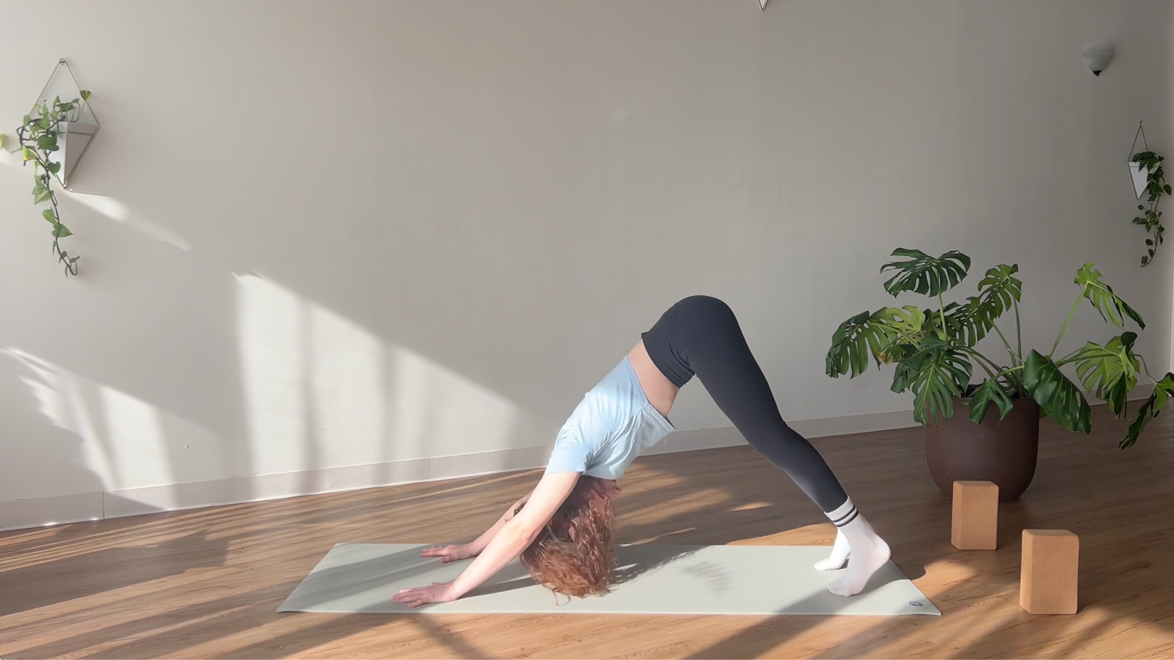 woman in Downward Dog pose on yoga mat