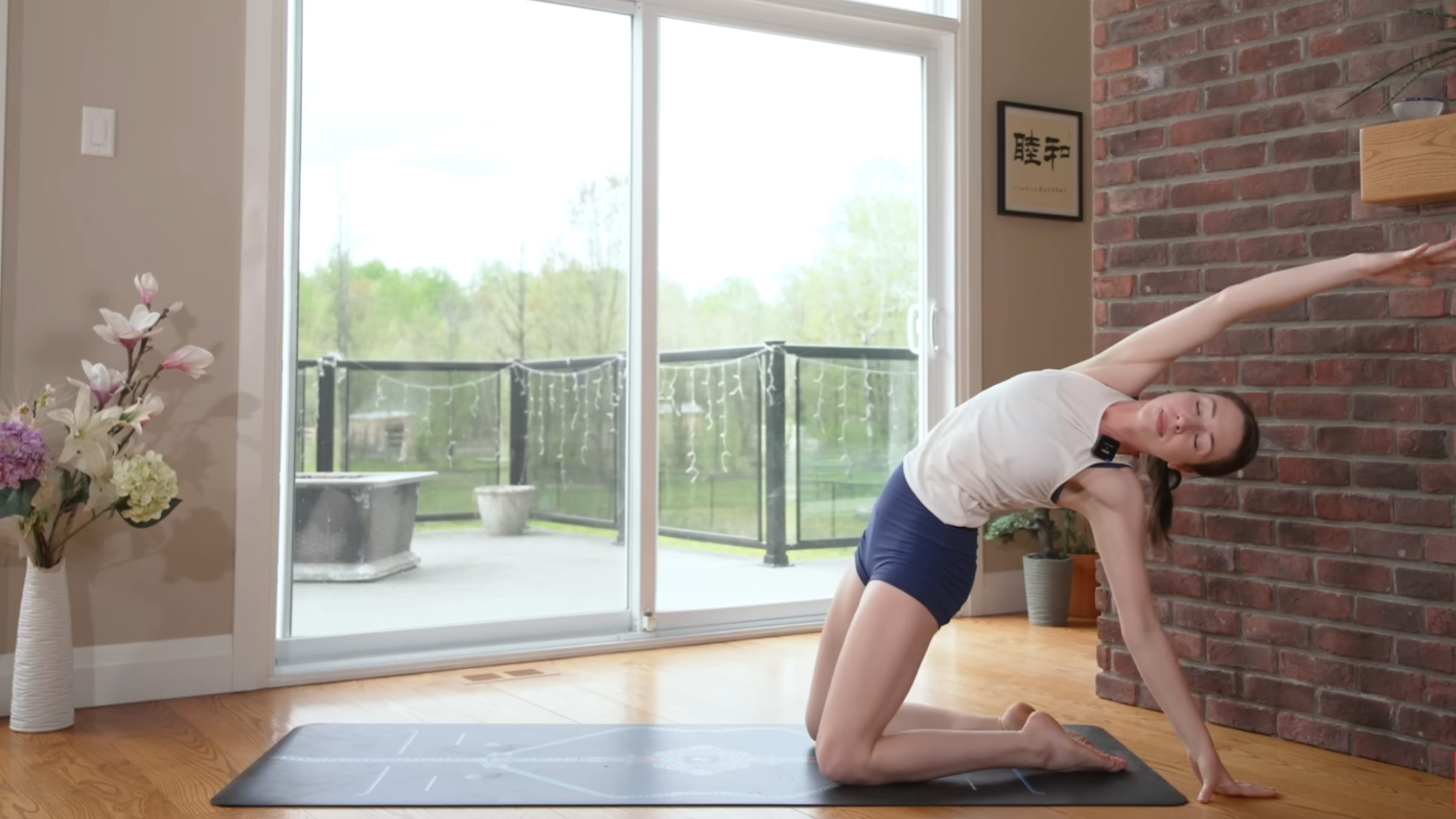 woman in half camel pose on yoga mat in home