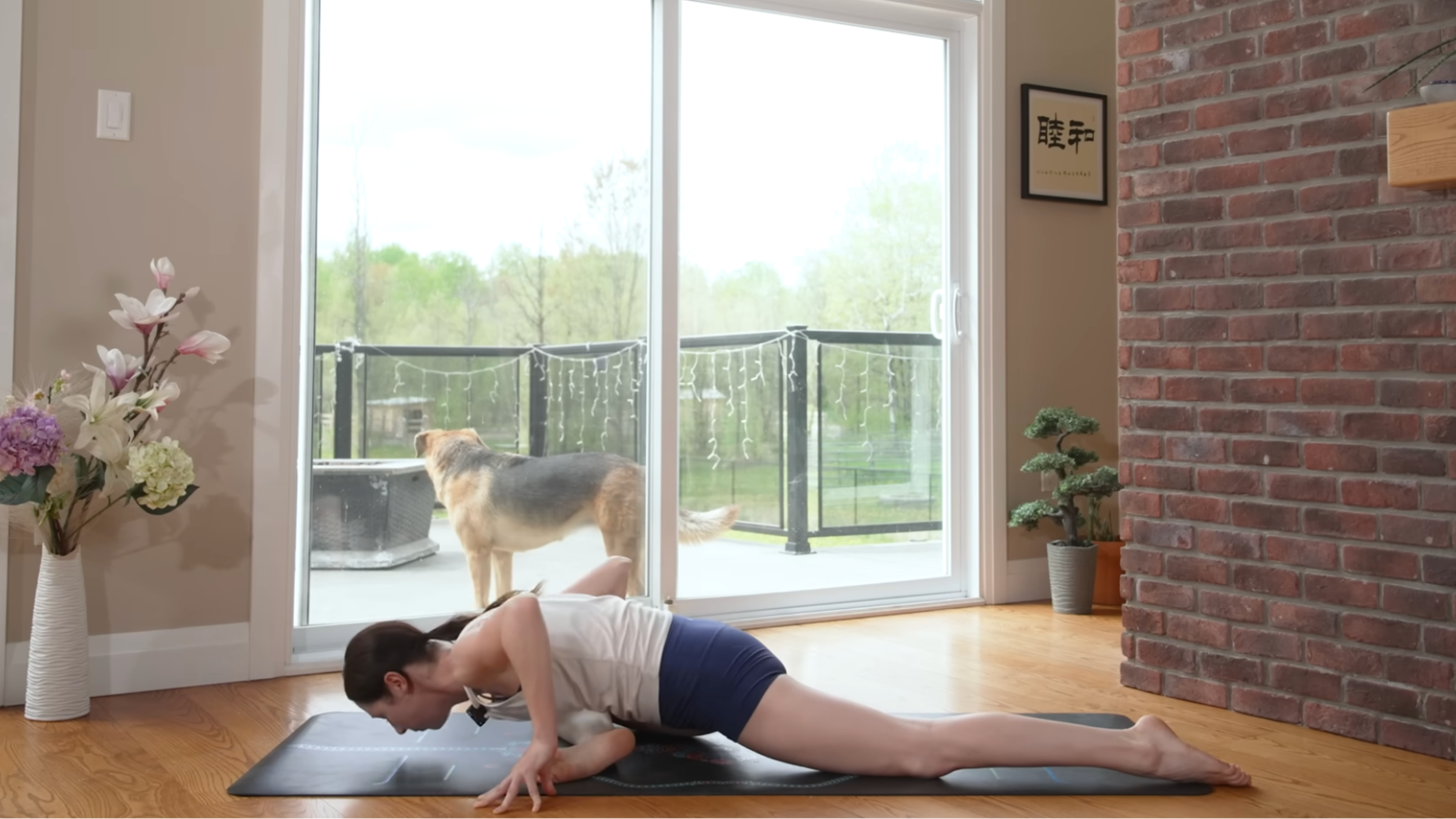 woman leaning forward over pigeon legs pose on yoga mat in home