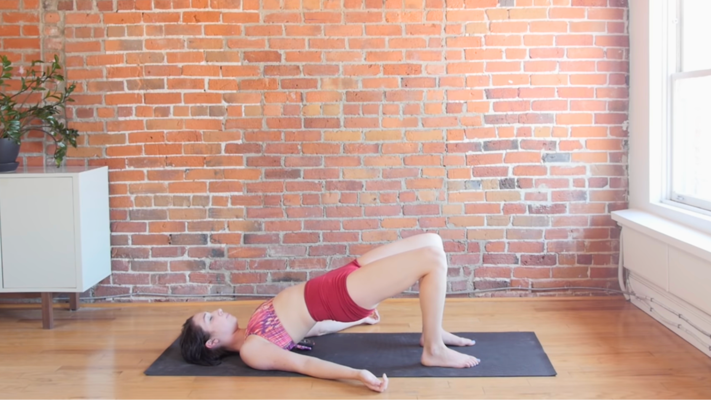 woman in bridge pose with hips lifted and shoulders and feet on the mat