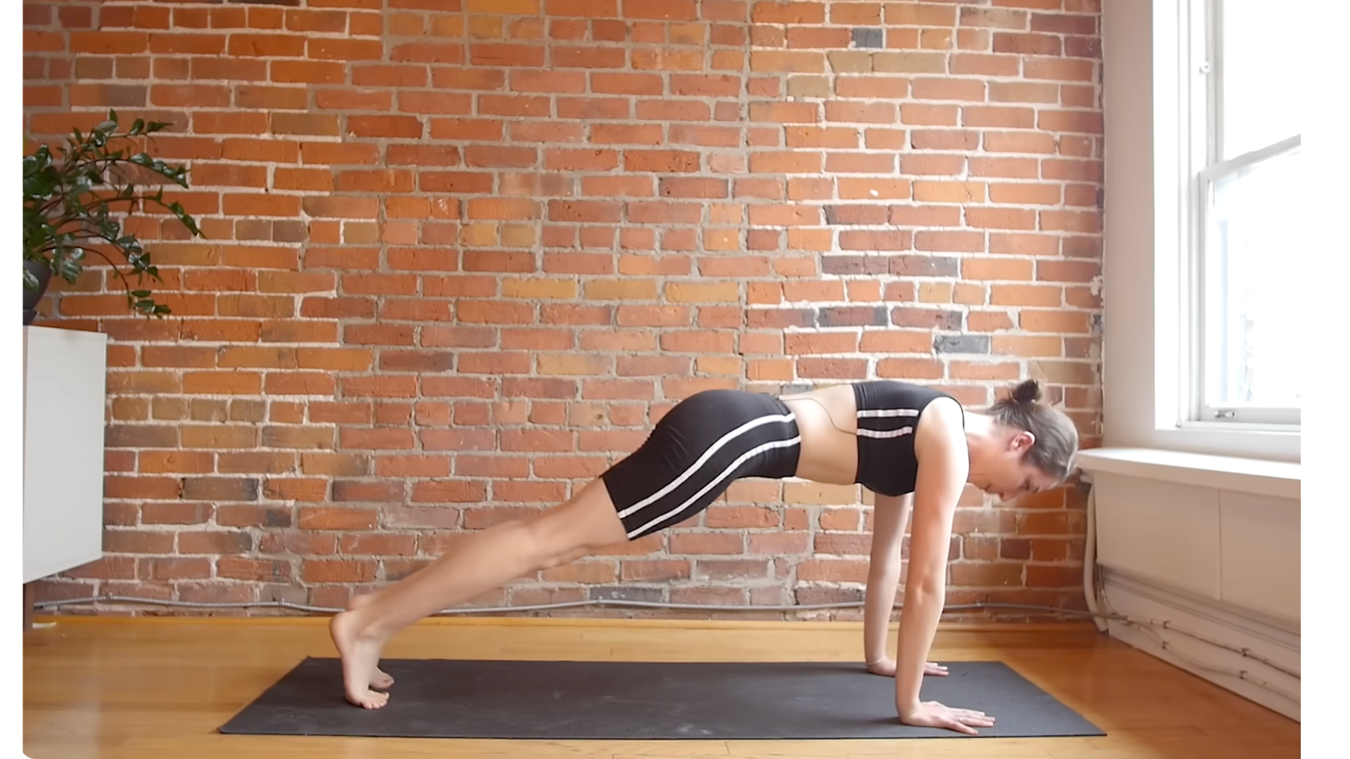 Yoga teacher in Plank Pose on a mat during a 10-minute morning yoga routine