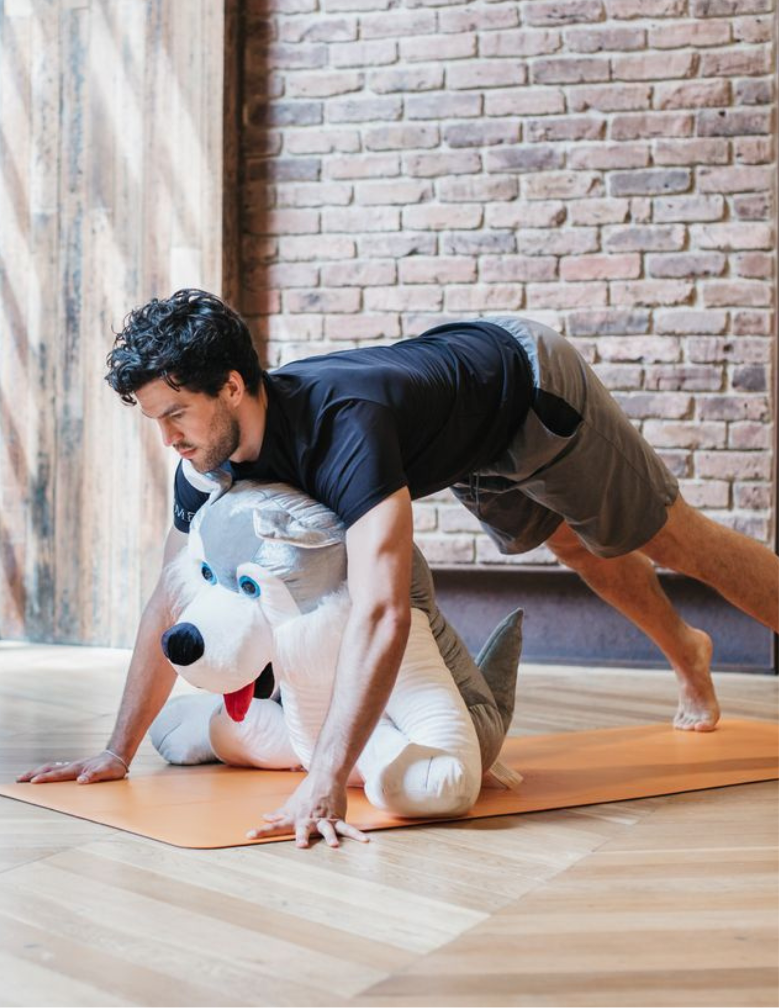 Yoga teacher on a mat placed on a hardwood floor
