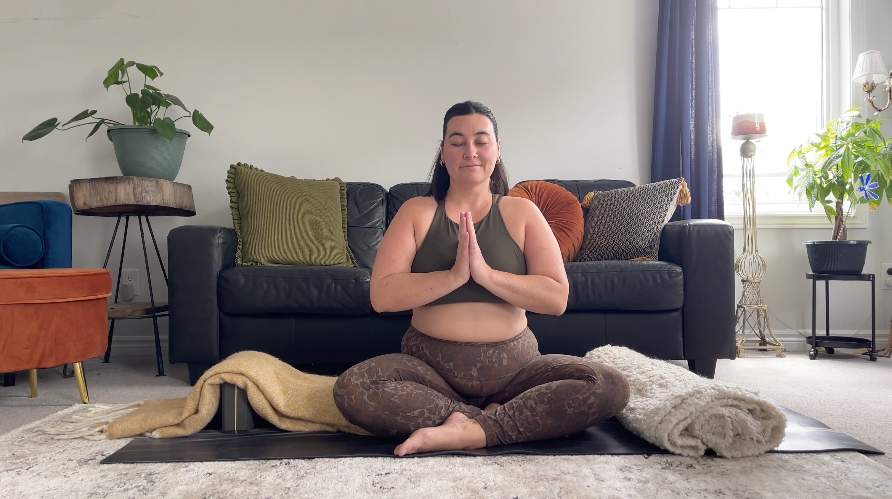 a woman in a restorative yoga pose, seated pose