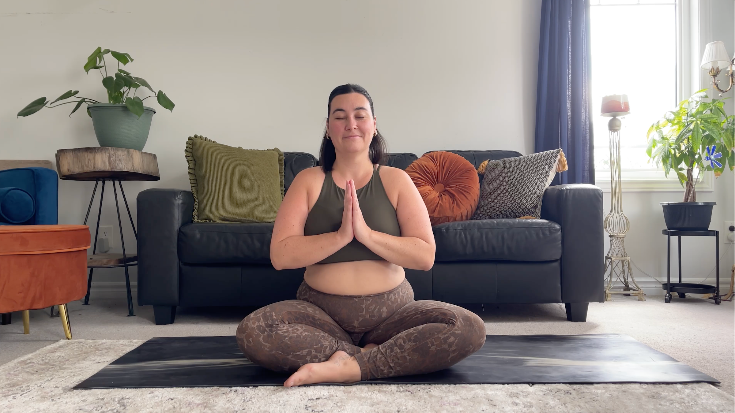 A woman seated cross-legged on a yoga mat