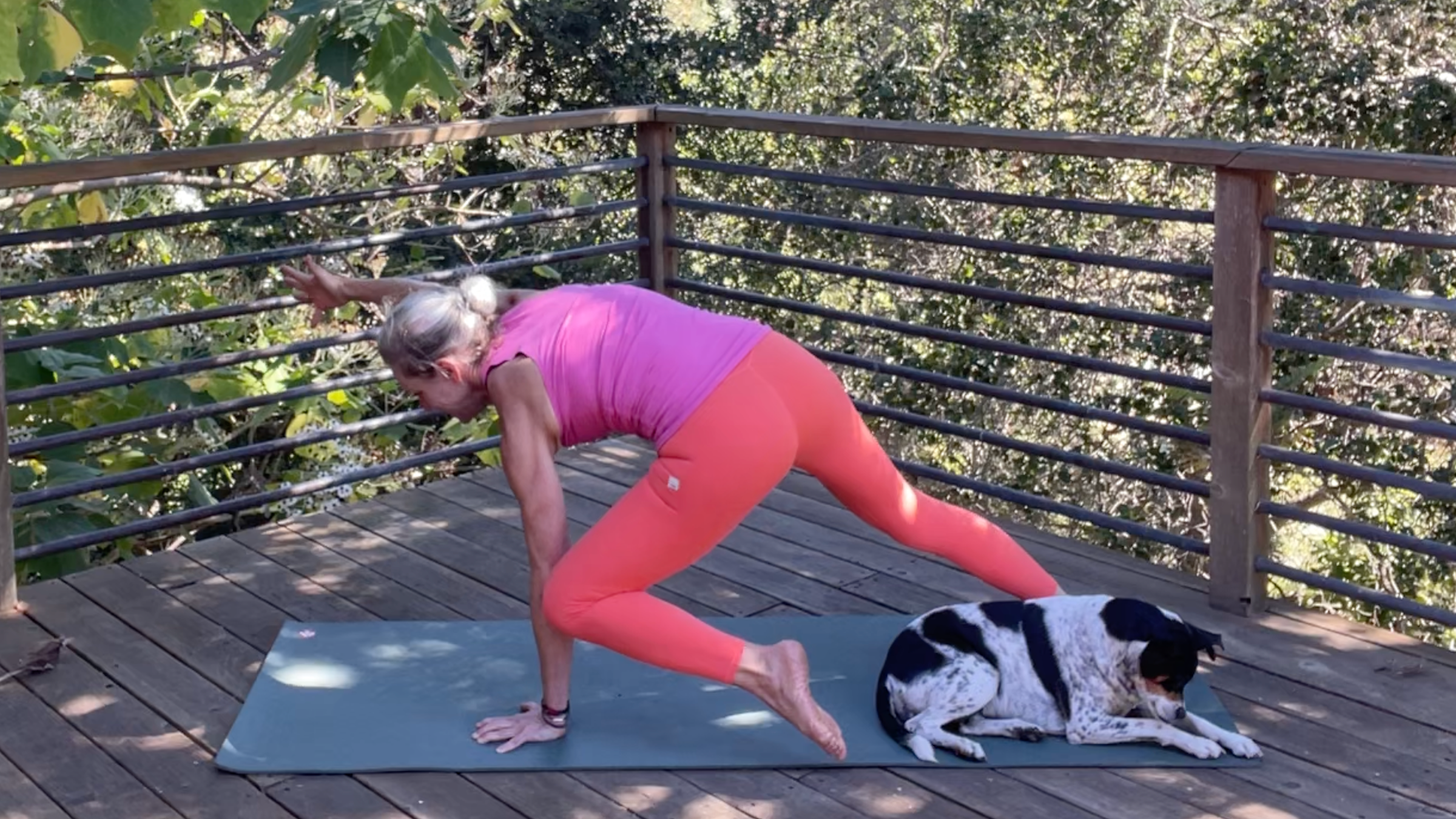 Andrea Marcum practicing her yoga for strength routine on a mat outside