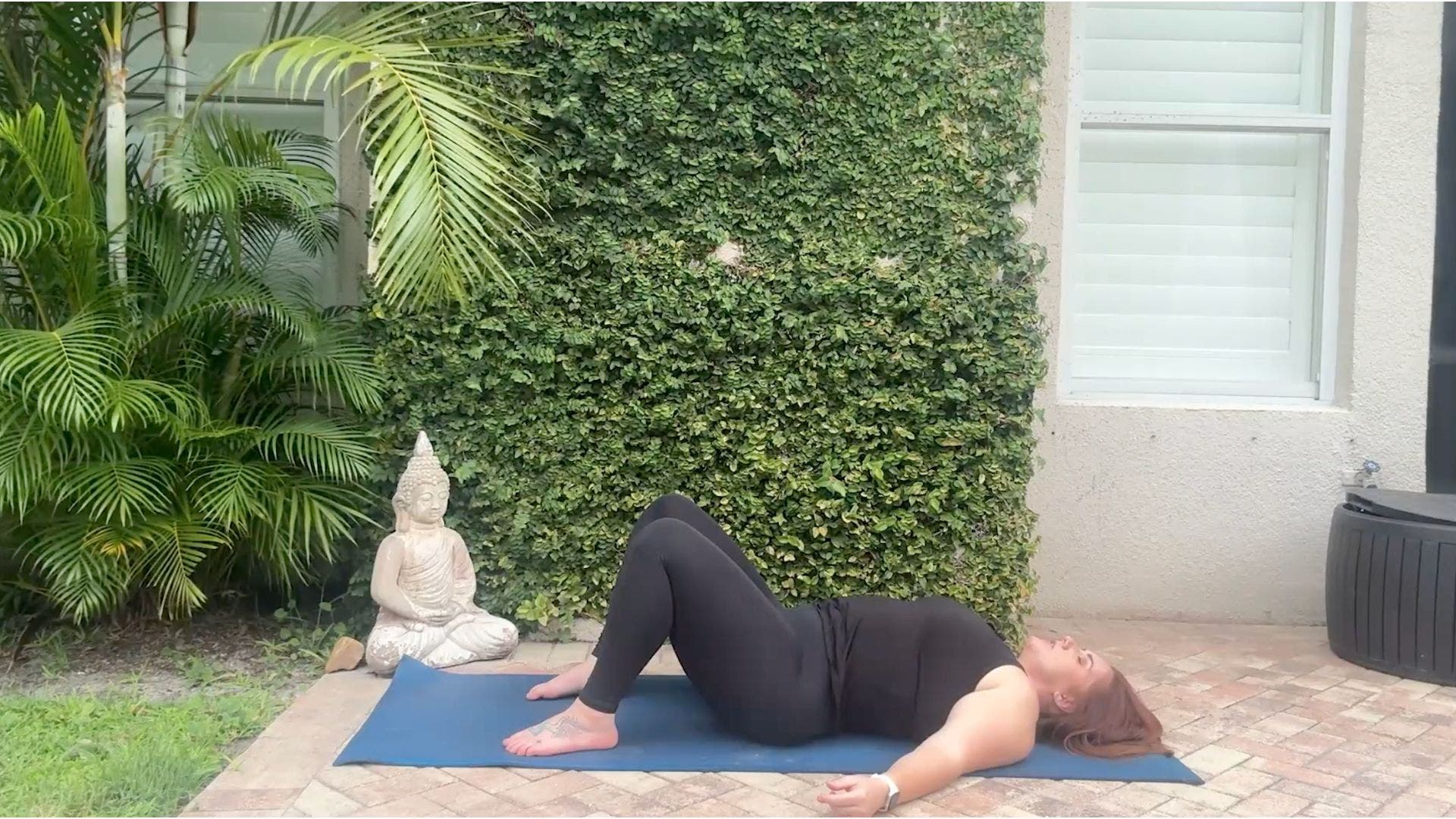 Woman on yoga mat tilting pelvis.