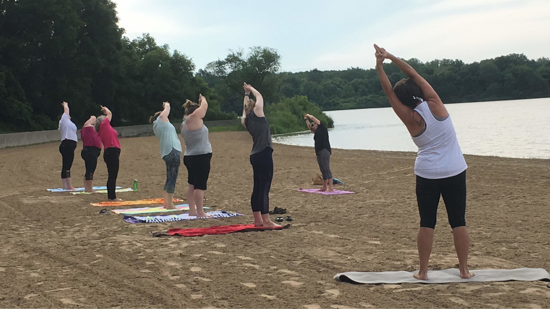 Yoga teacher Marian Hall leading a class long a beach