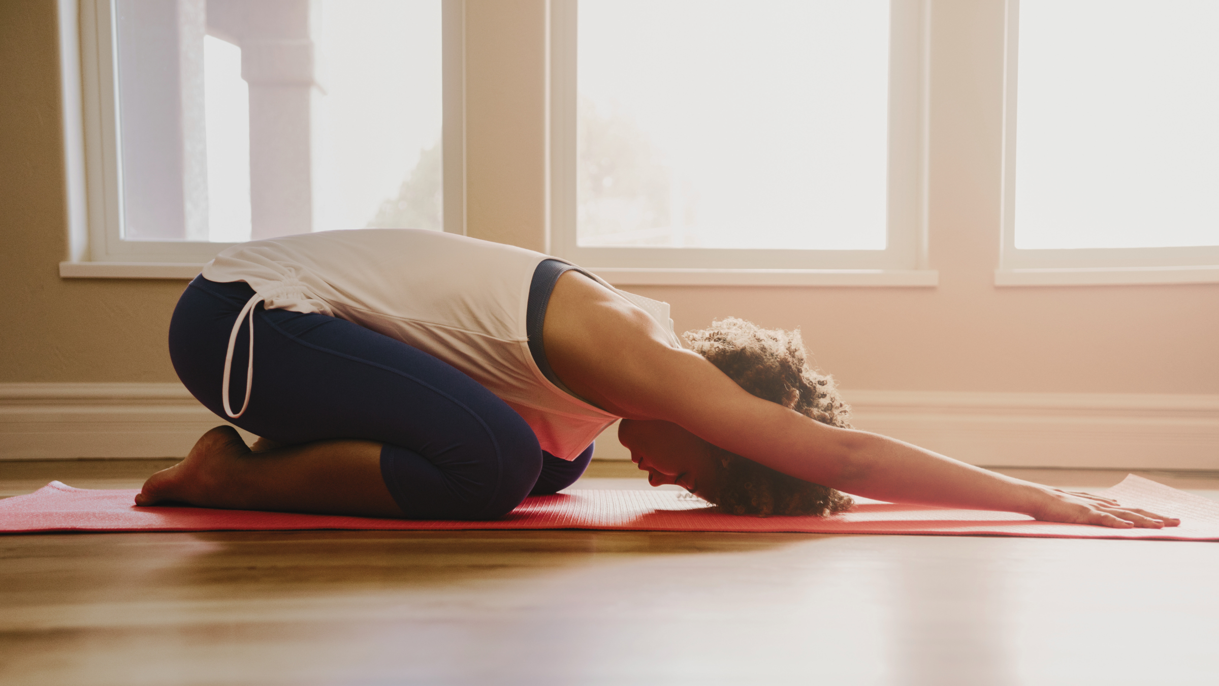 A woman practicing lazy yoga in Child's Pose