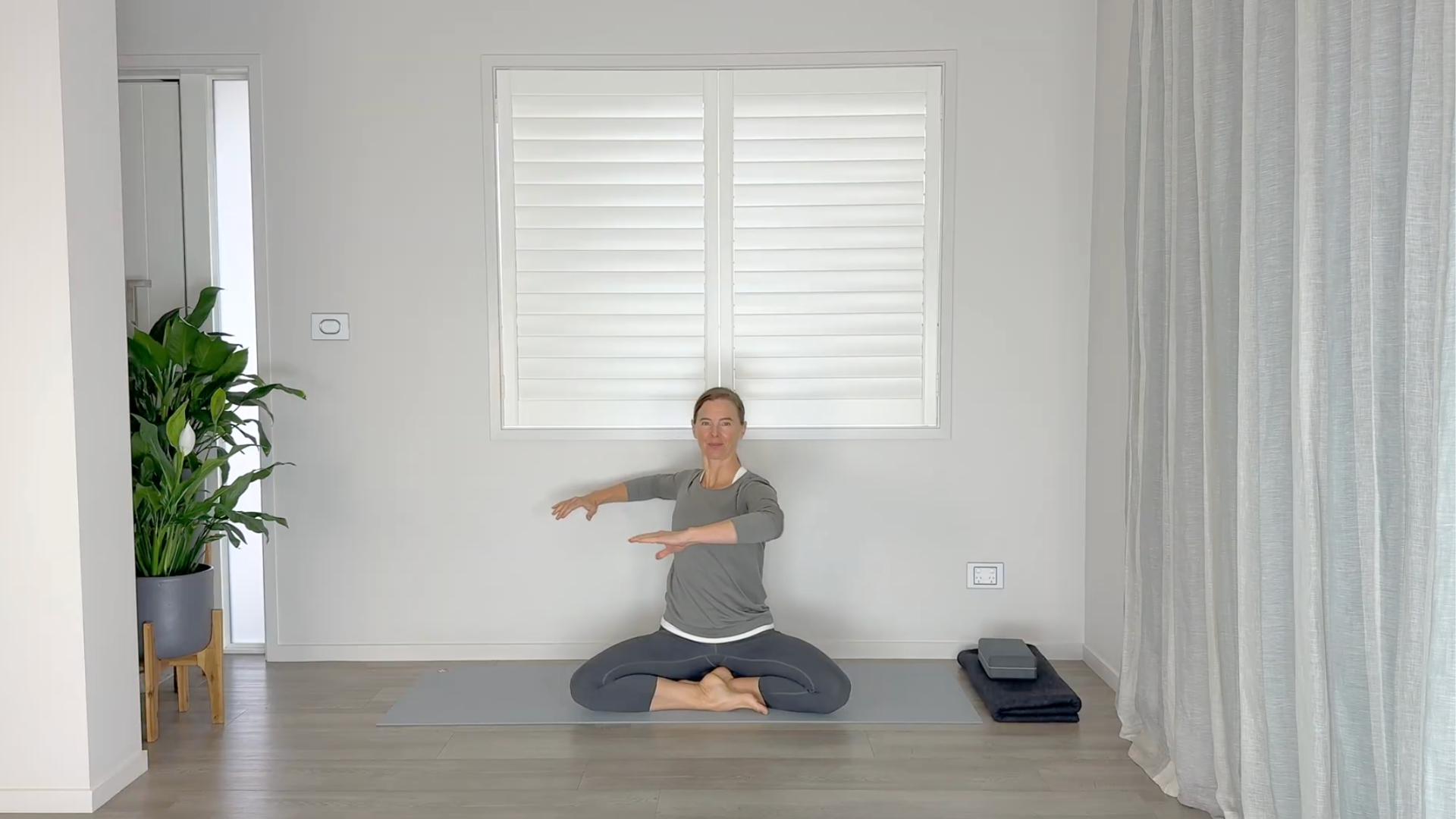 Yoga teacher Rachel Land practicing seated mid-back stretches