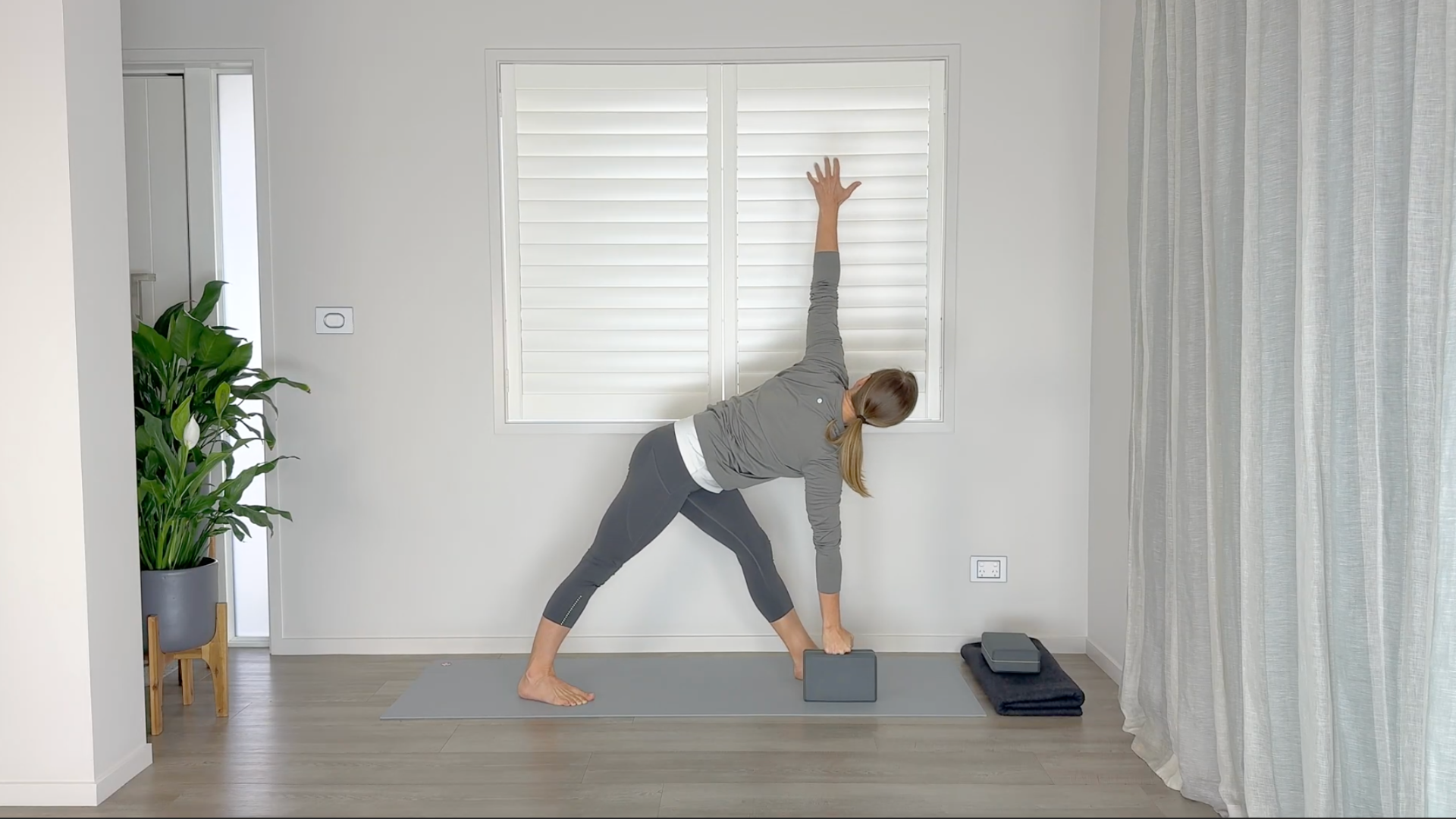 Woman on a yoga mat twisting for a mid-back stretch