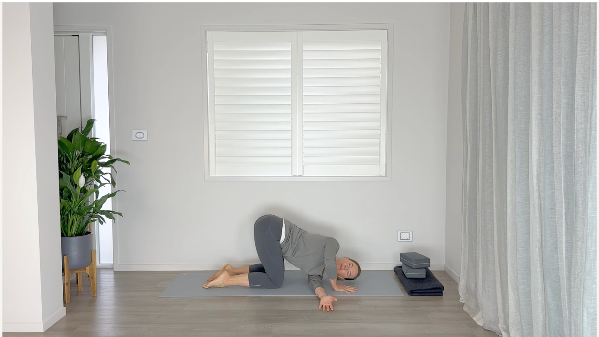 Yoga teacher practicing stretches for the mid back on a mat