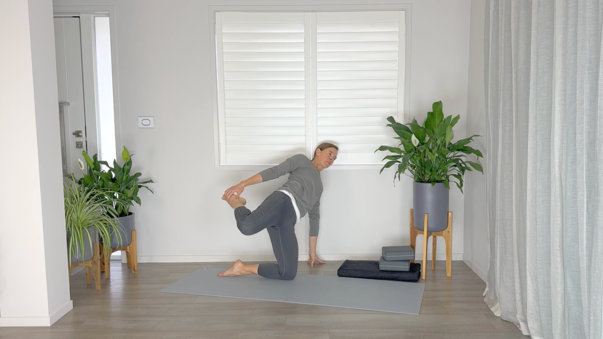 Yoga teacher practicing a quad stretch variation of Side Plank