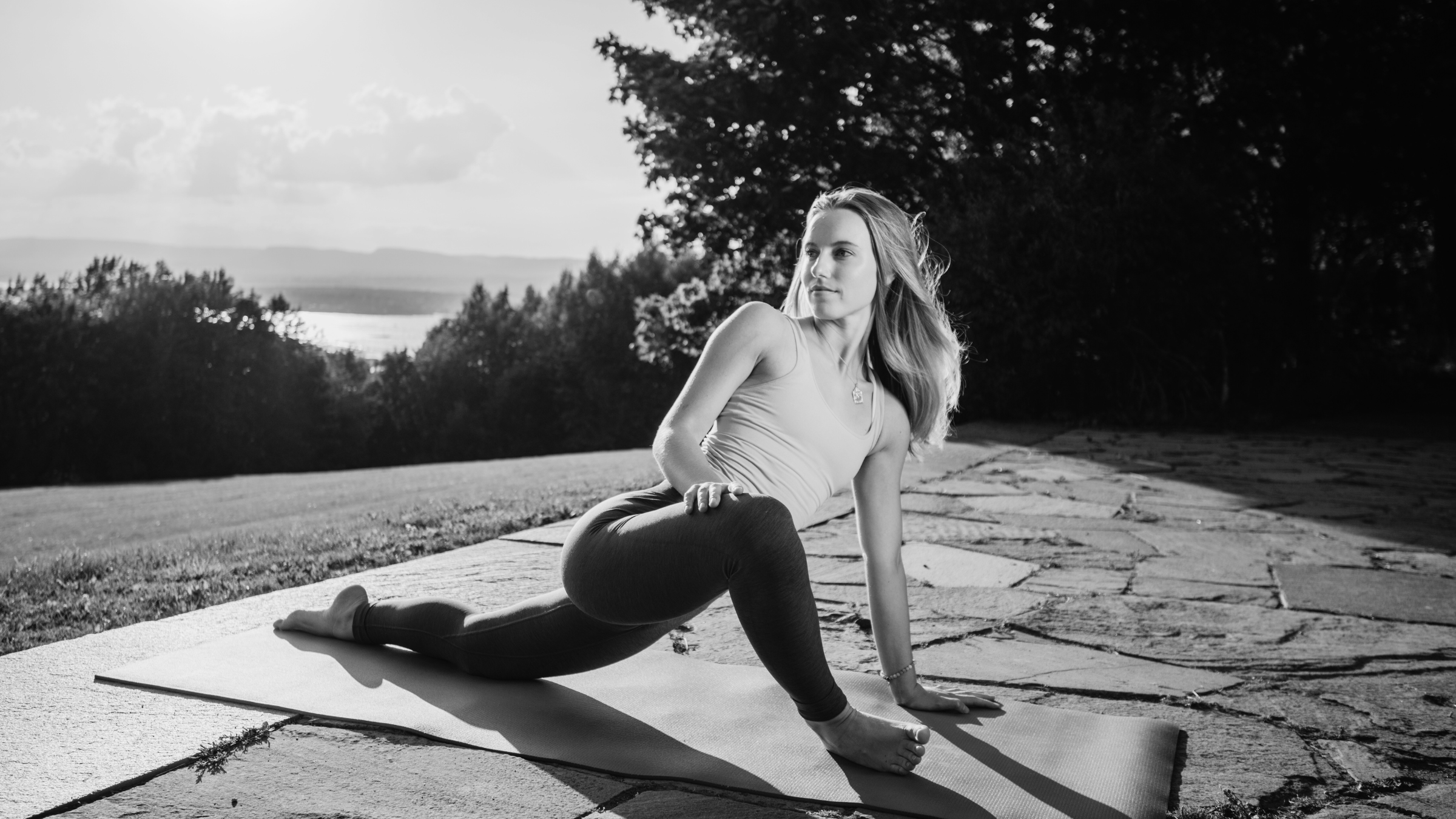 A woman practicing Twisted Lizard Pose outside