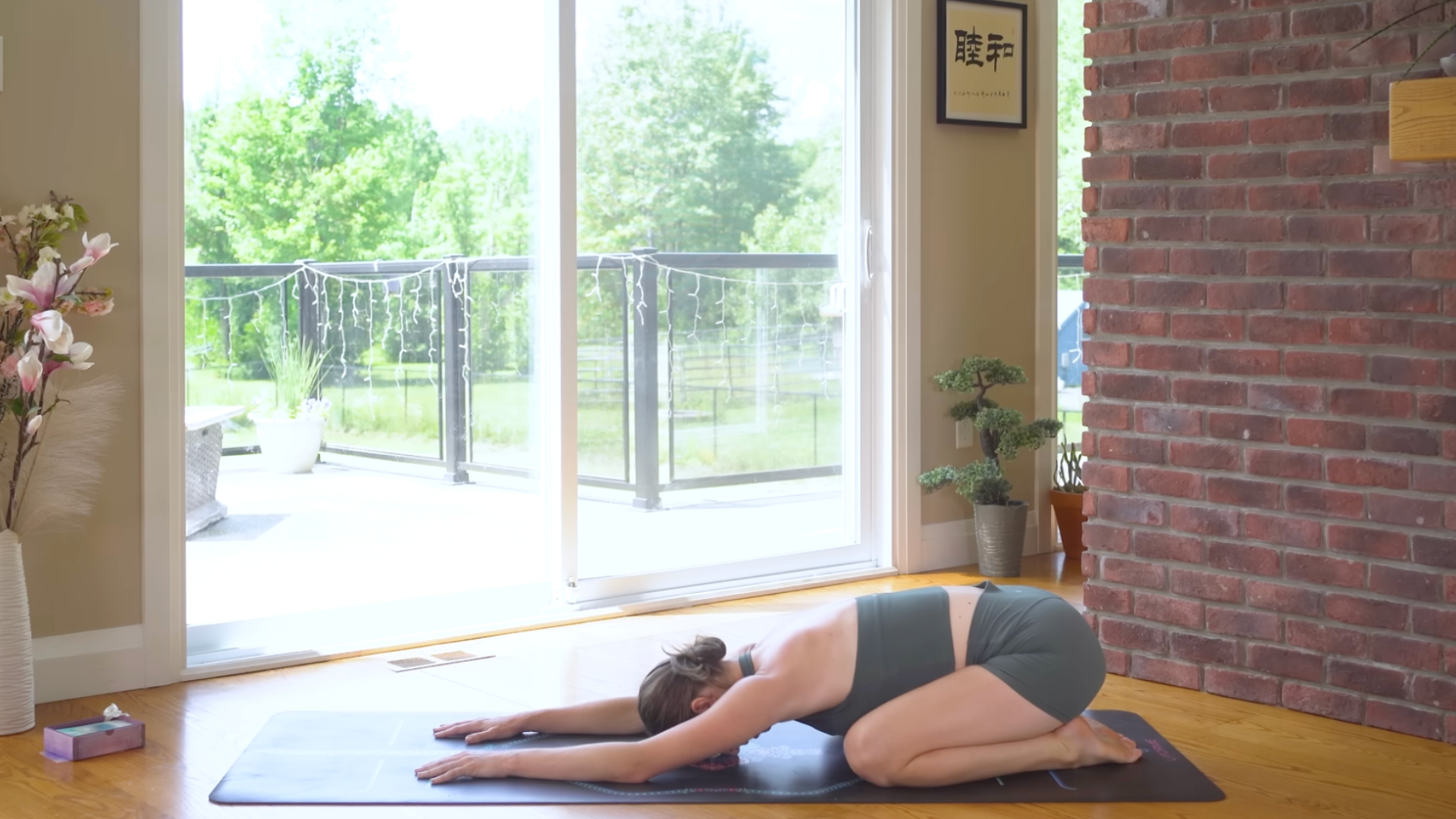 Yoga With Kassandra in Child's Pose while practicing a 10-minute morning yoga routine