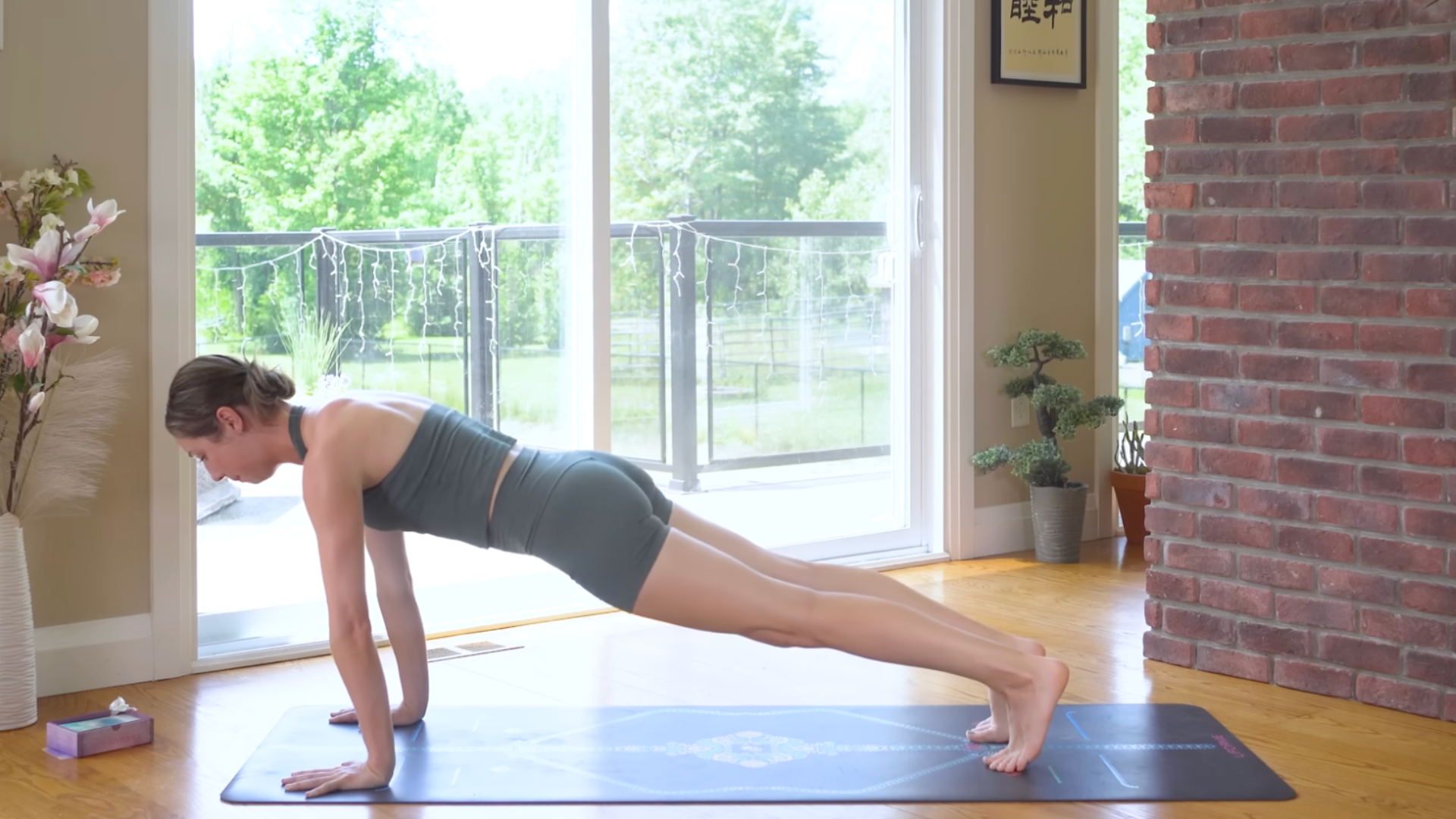 Woman on a mat in Plank Pose or the top of a push-up while practicing pilates core exercises