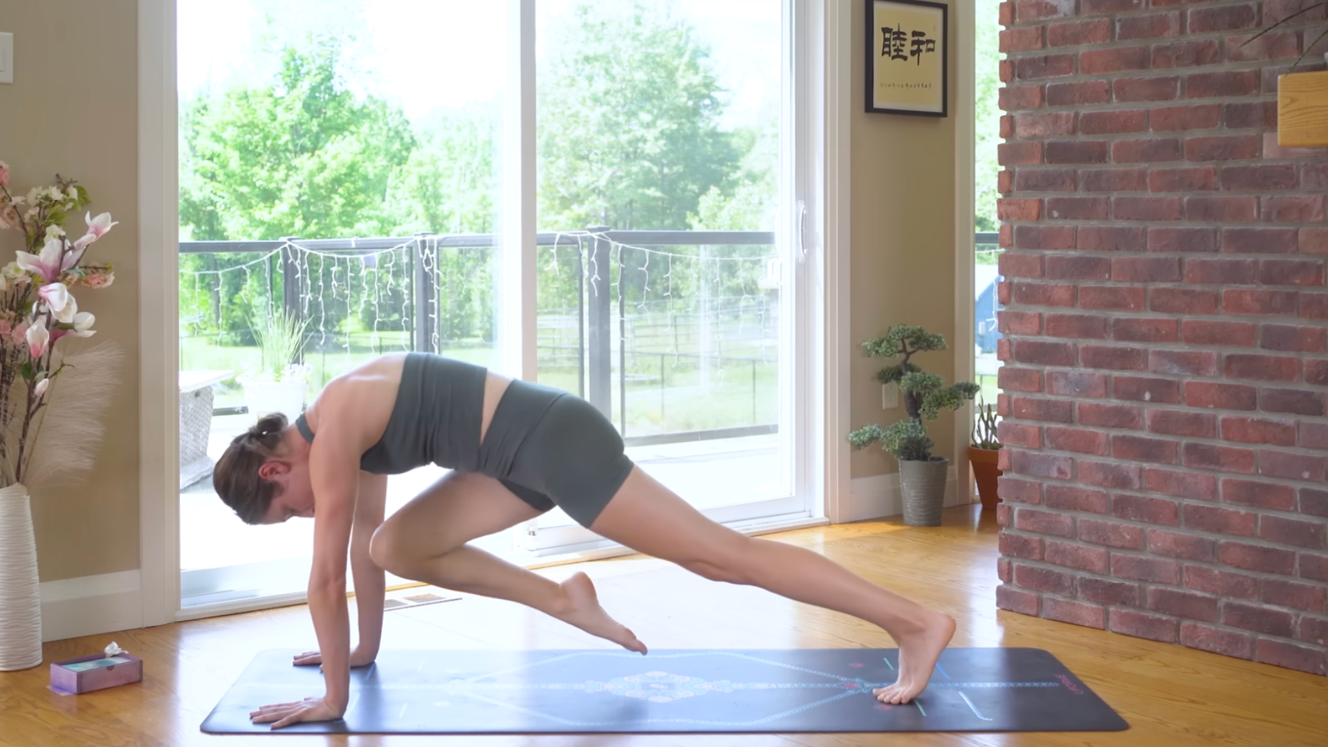 Woman on a yoga mat bringing her knee toward her nose in Plank Pose during a 10-minute morning yoga routine