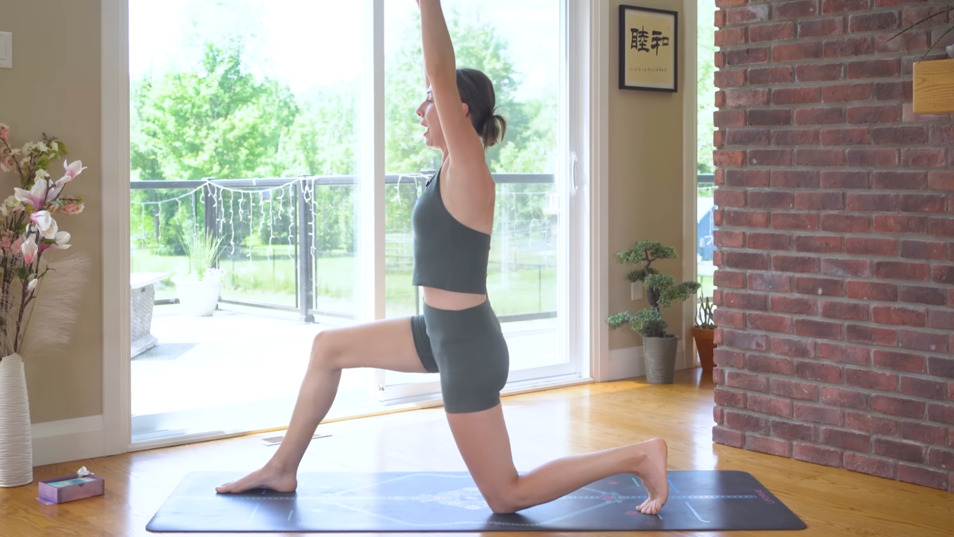 Yoga teacher practicing Low Lunge on a grippy mat while doing Pilates core exercises