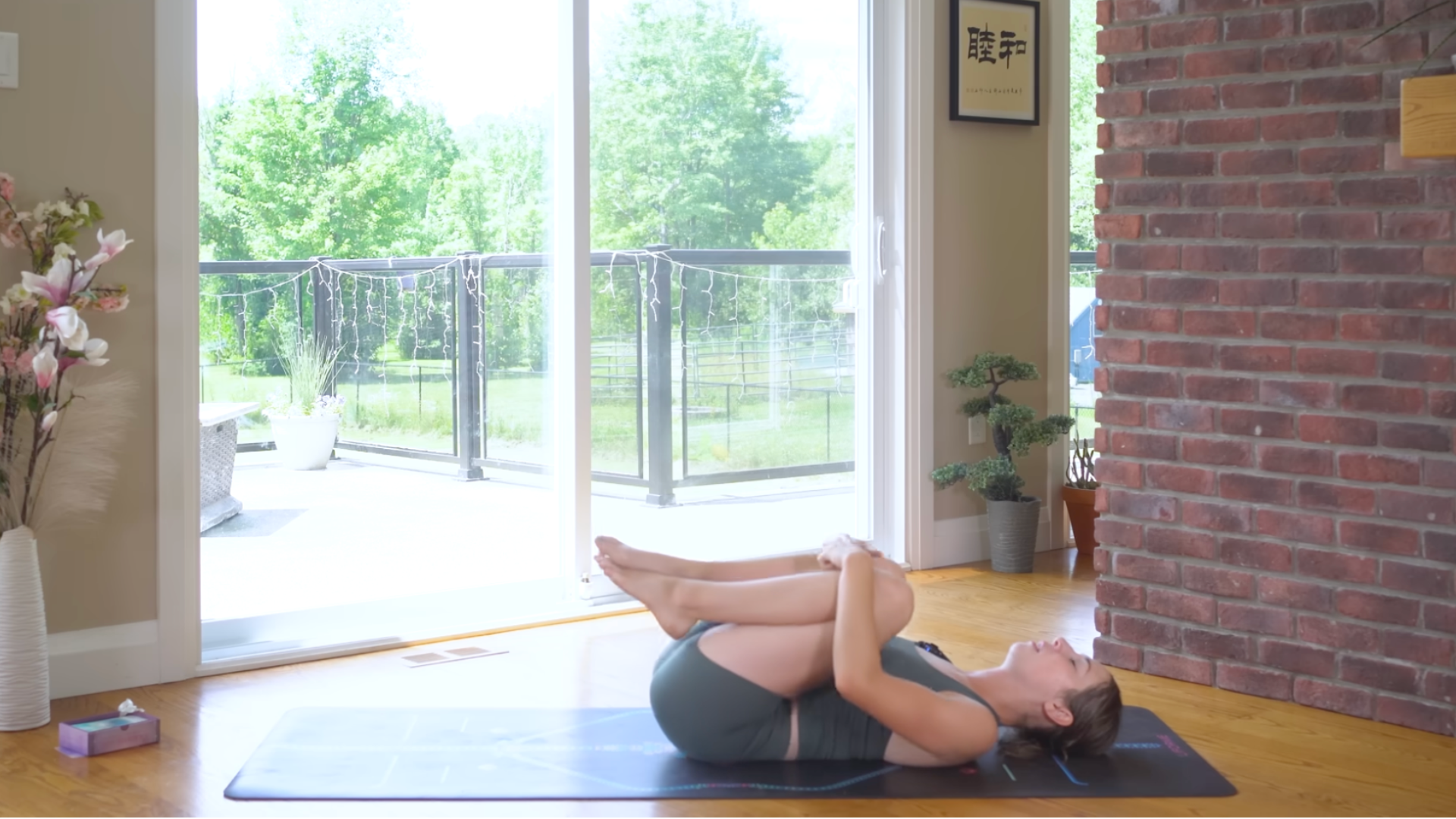 Yoga teacher lying on her back practicing 10-minute morning yoga