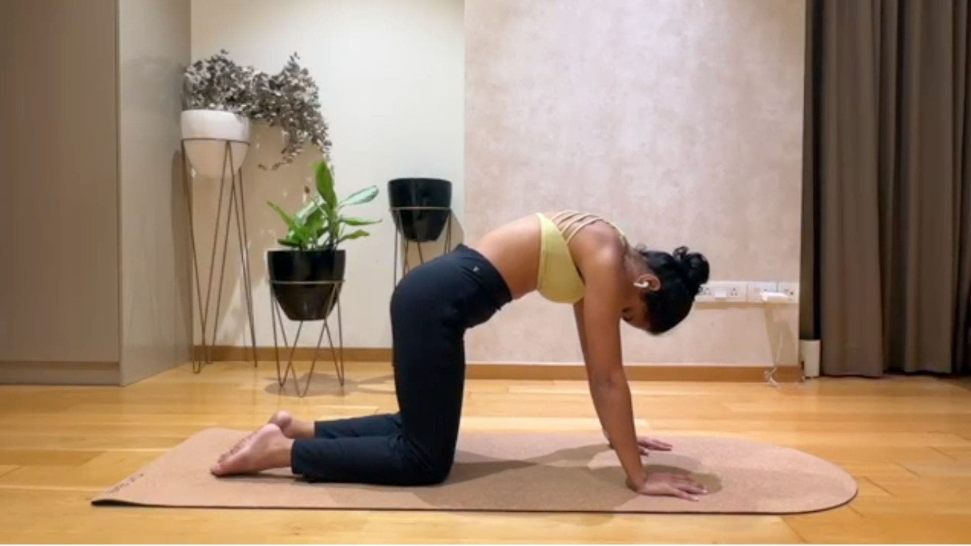 Image of yoga teacher Riya Davda in Cat Pose.