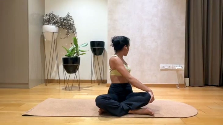 Image of yoga teacher Riya Davda in seated twist.