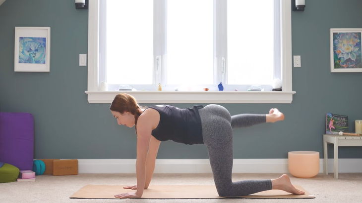 woman in tabletop pose on yoga mat but with right knee bent, foot flexed and lifted out to right side of mat, with thigh parallel to floor while practicing anterior pelvic tilt exercises