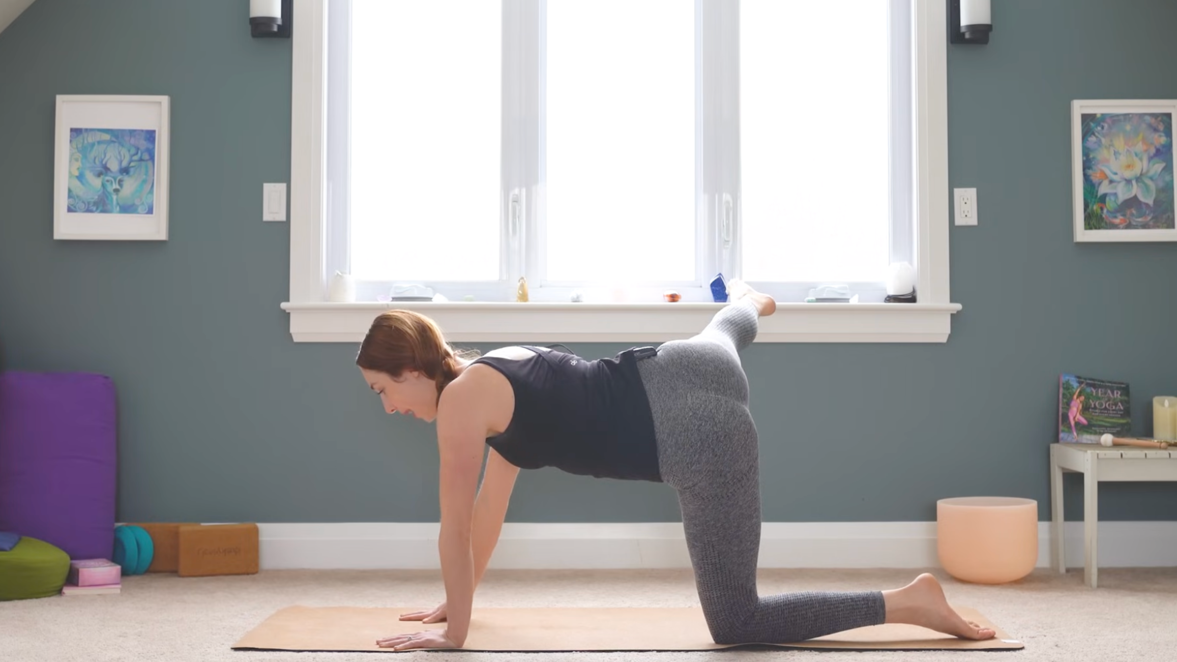 woman on yoga mat in tabletop position but with right leg extended out long past the right side of mat, parallel to the floor