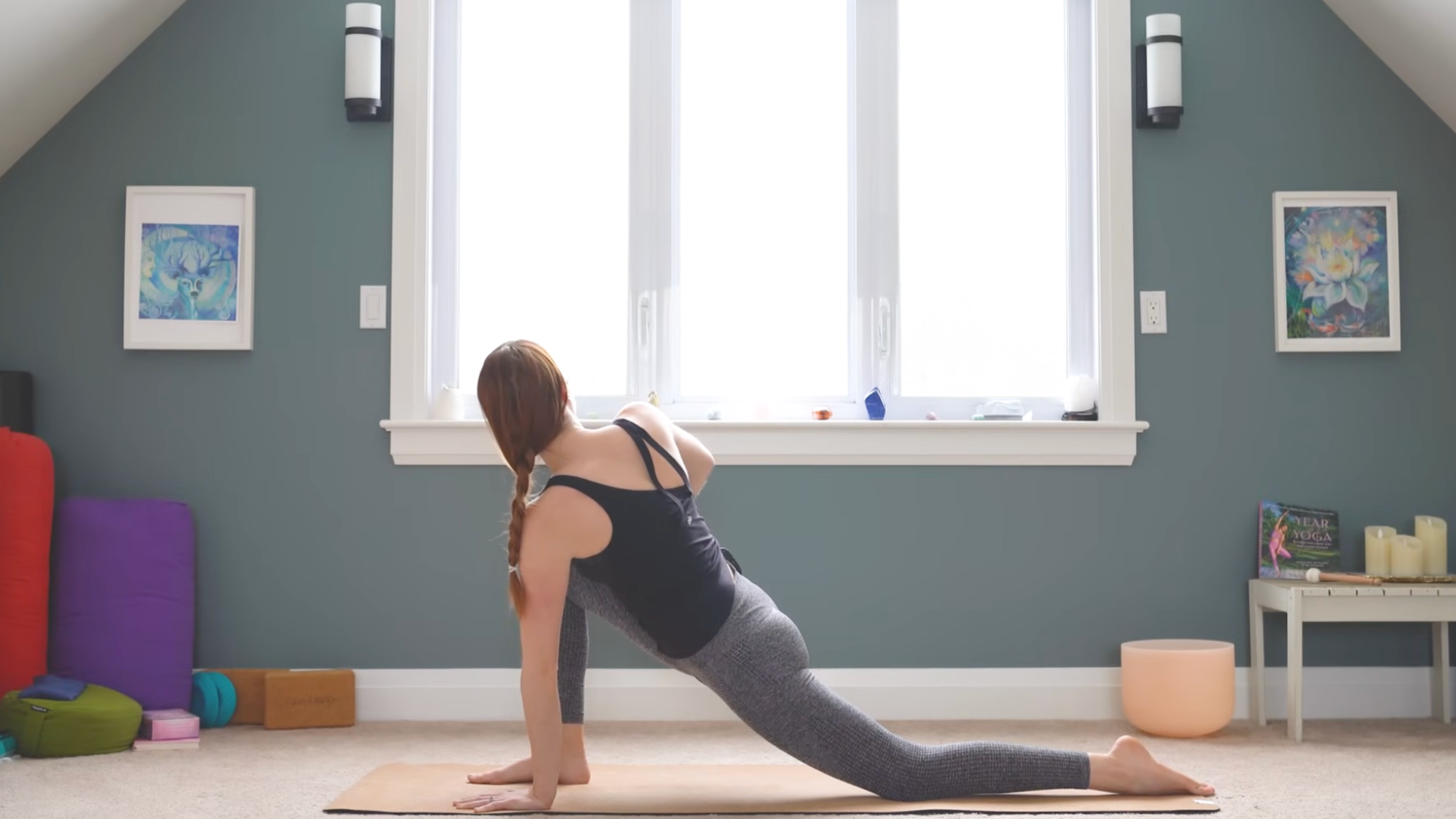 woman in yoga clothes in low lunge twist on mat with right leg forward and twisting toward the right